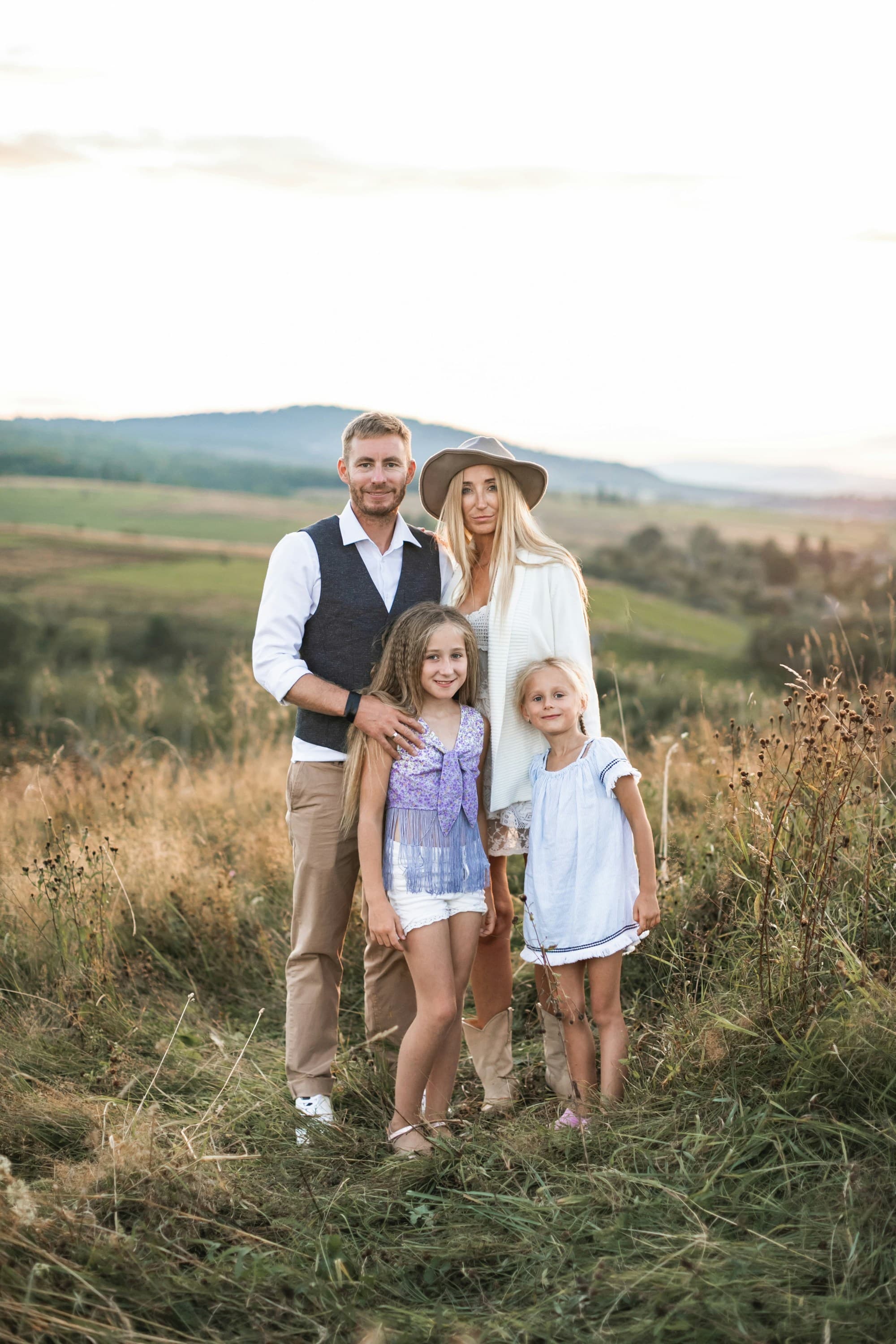 Three individuals standing in a field posing for a photo.