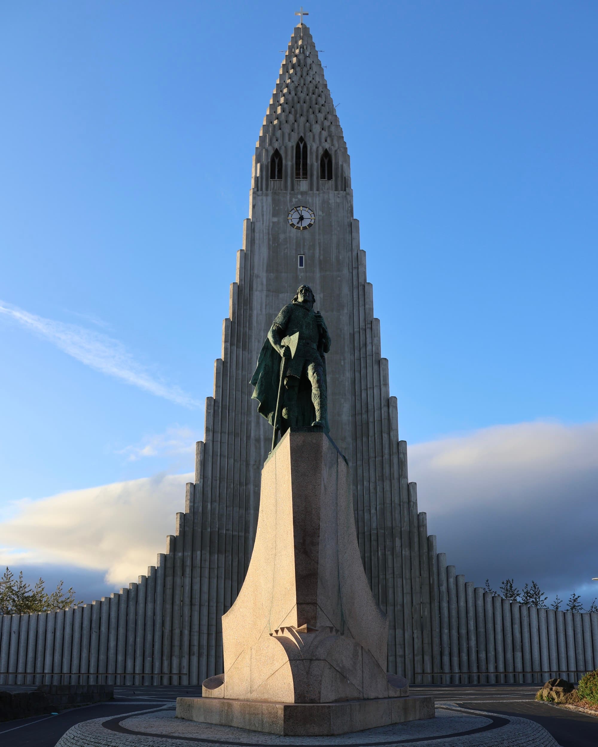 A tall tower with a statue of a man in the front during the daytime
