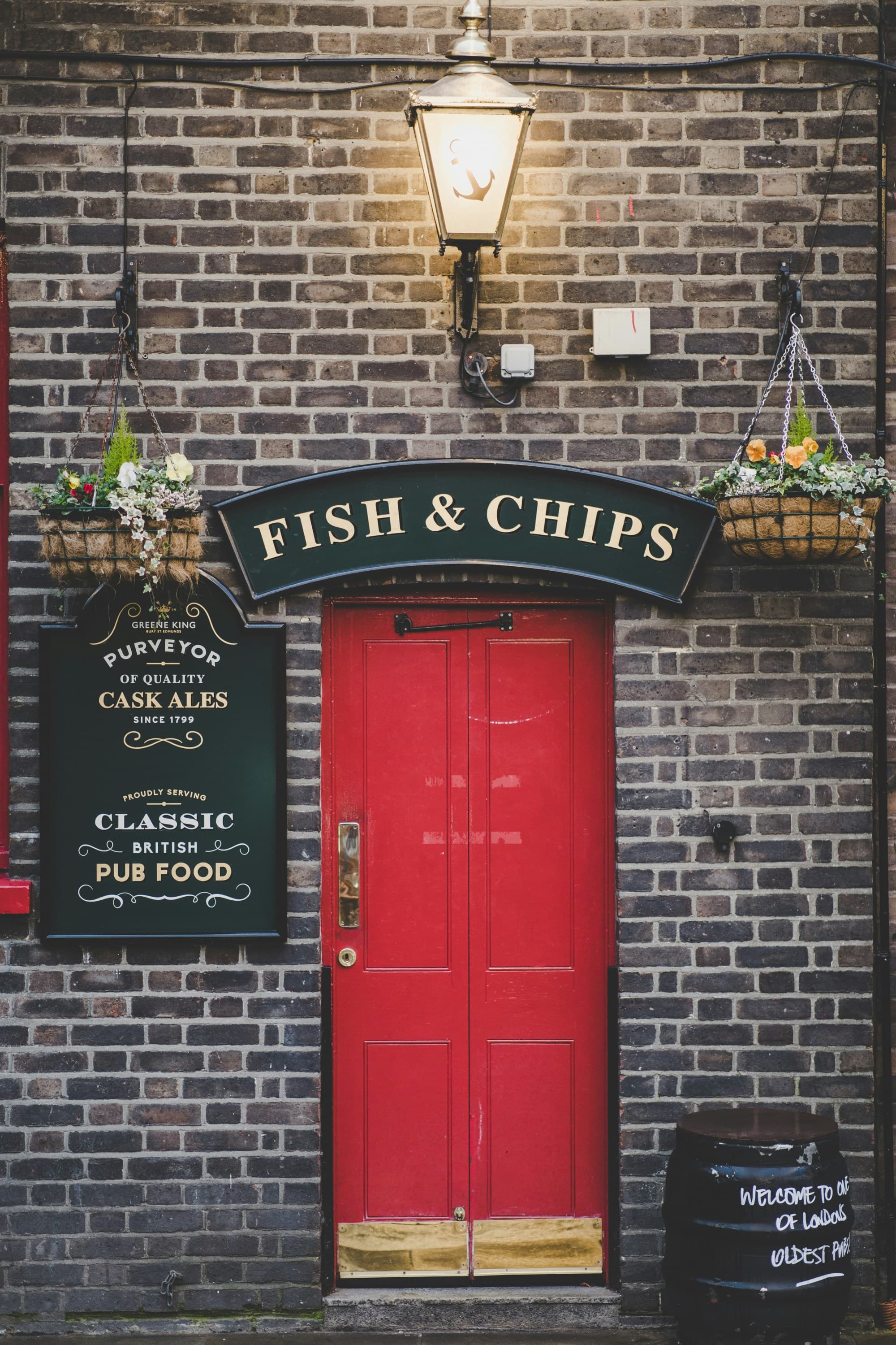 A charming British pub with a red door and a sign for "fish & chips."