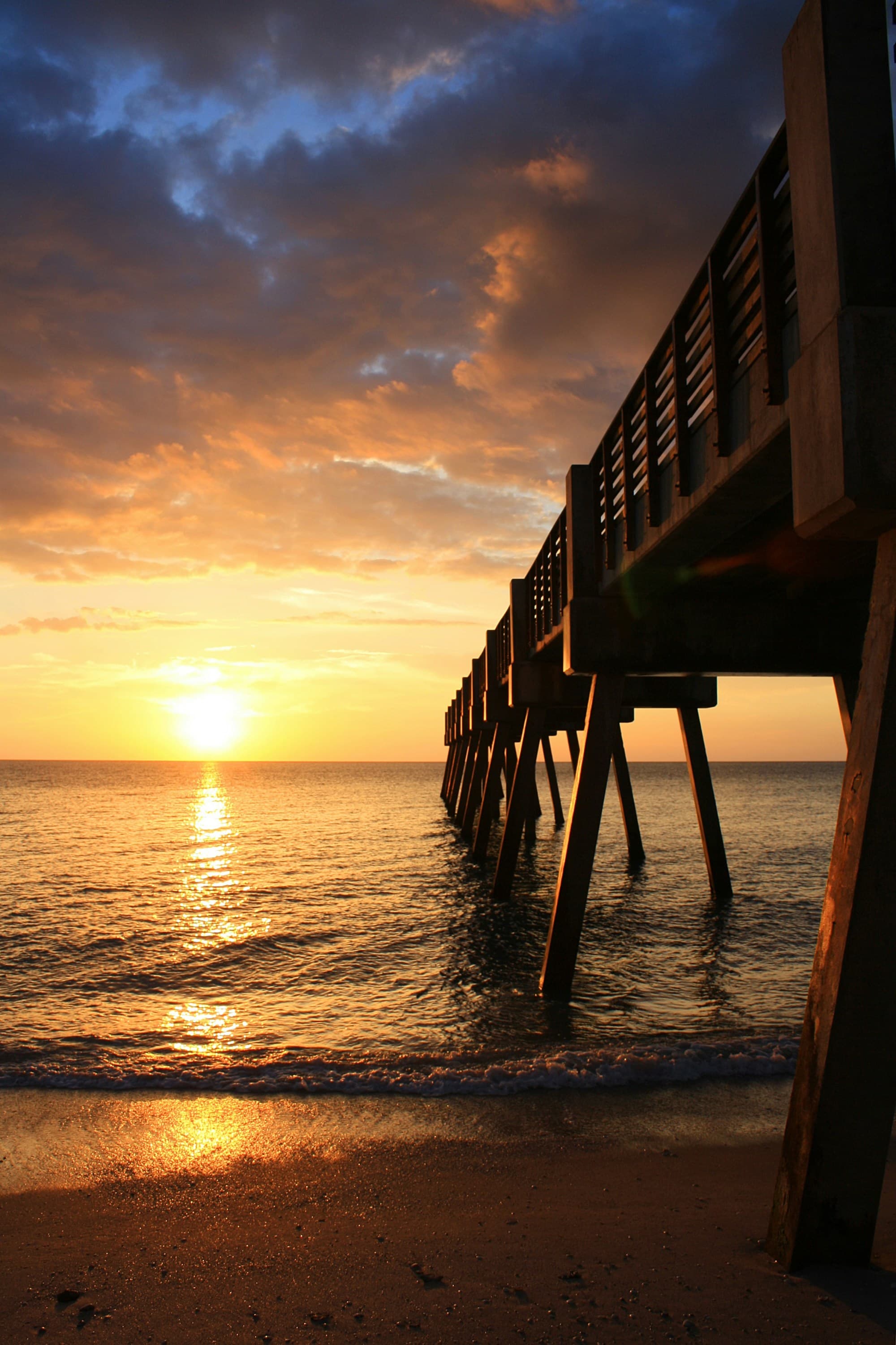 A pier out over the water at sunset.