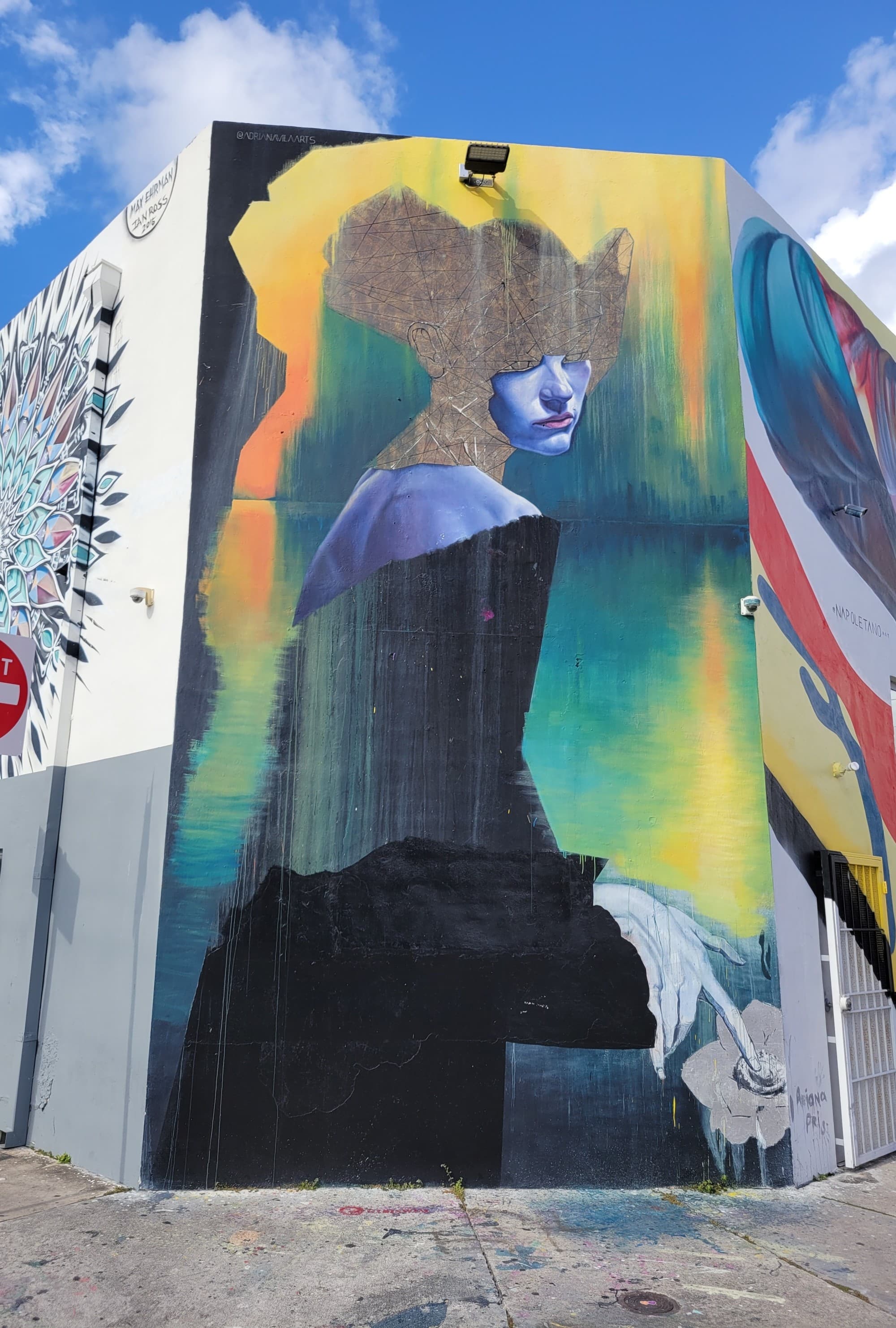 street art of a woman's face in blue green and yellow paint