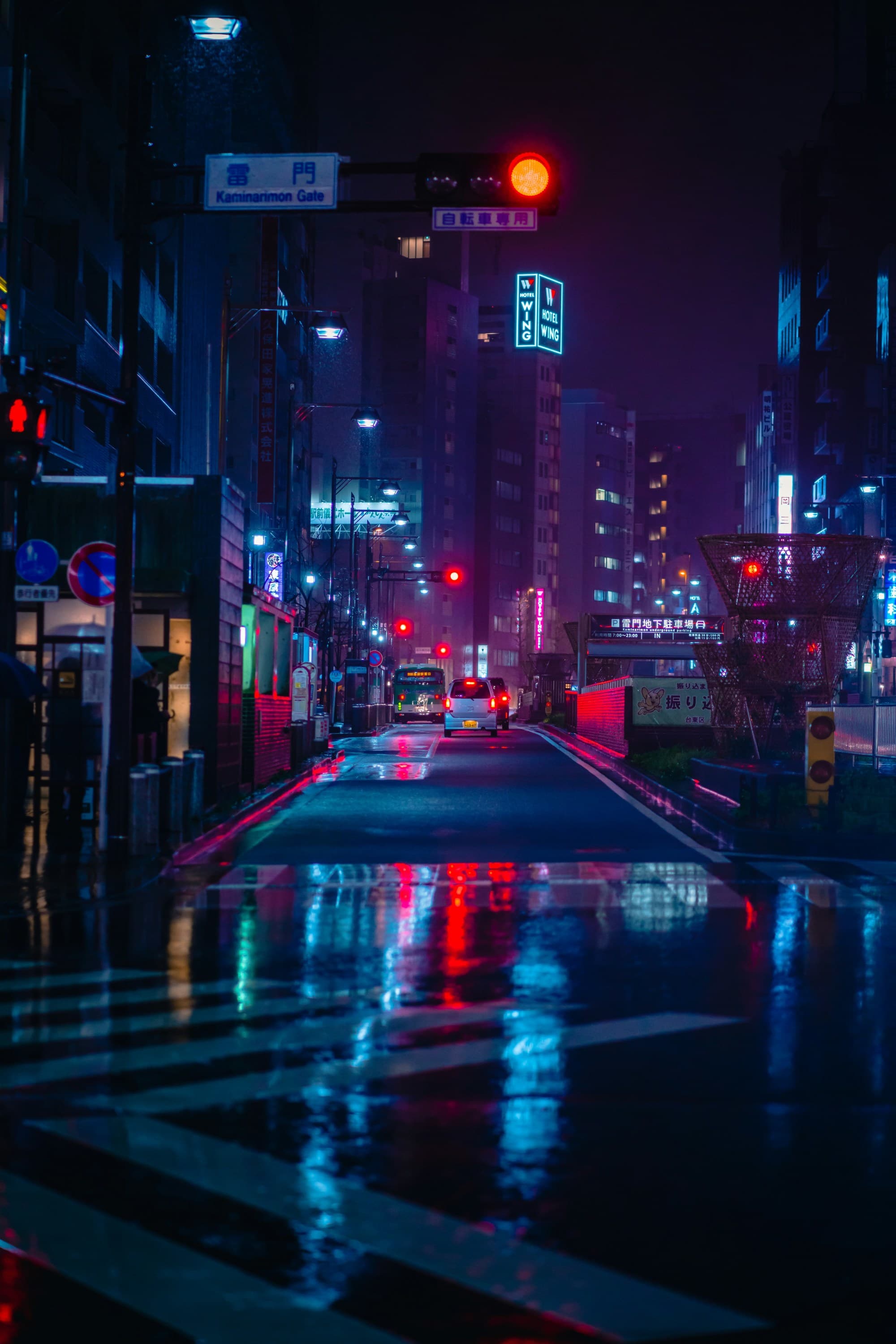 A picture of the street with neon colored sign boards at nighttime.