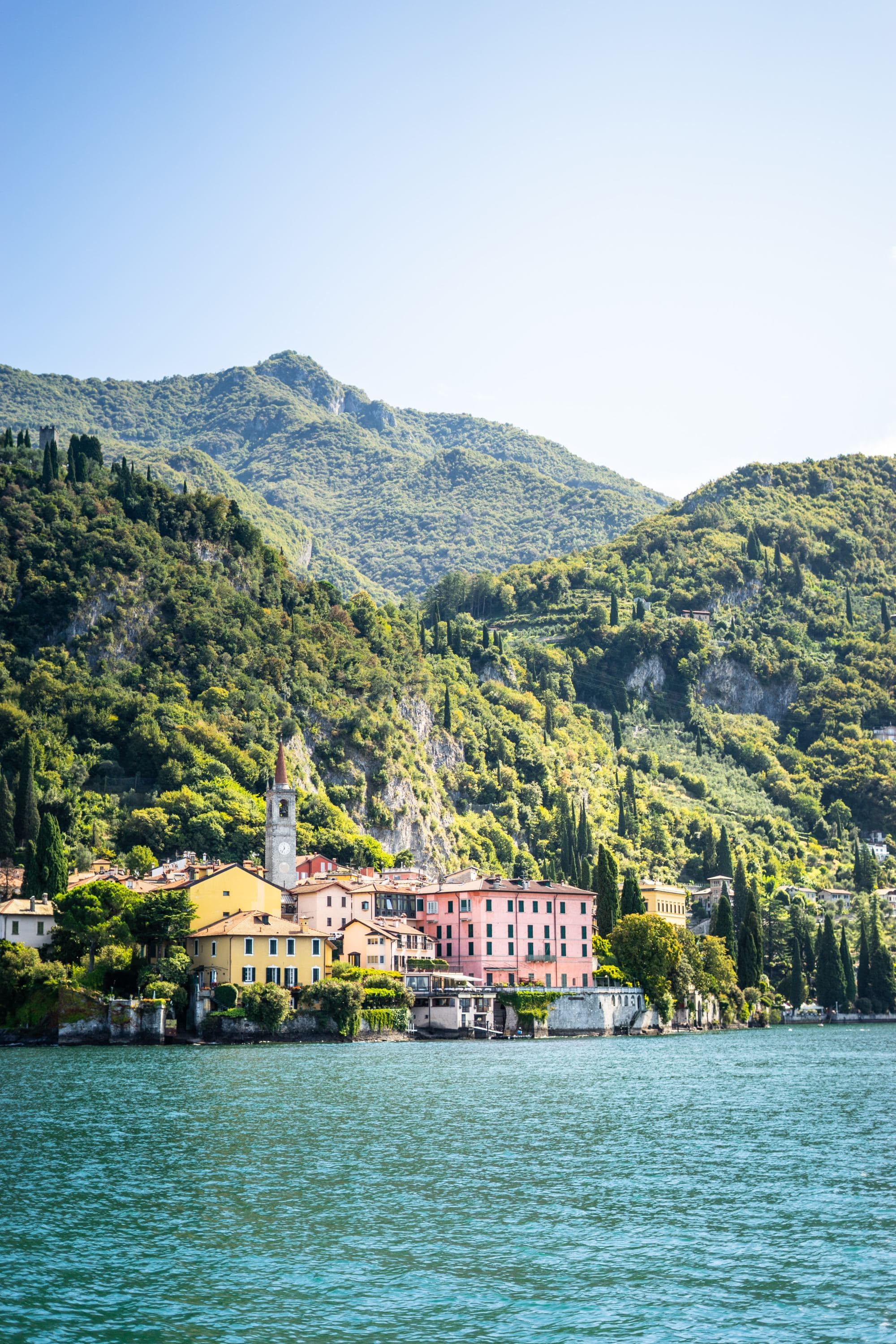 A lake with buildings and mountains at the back.