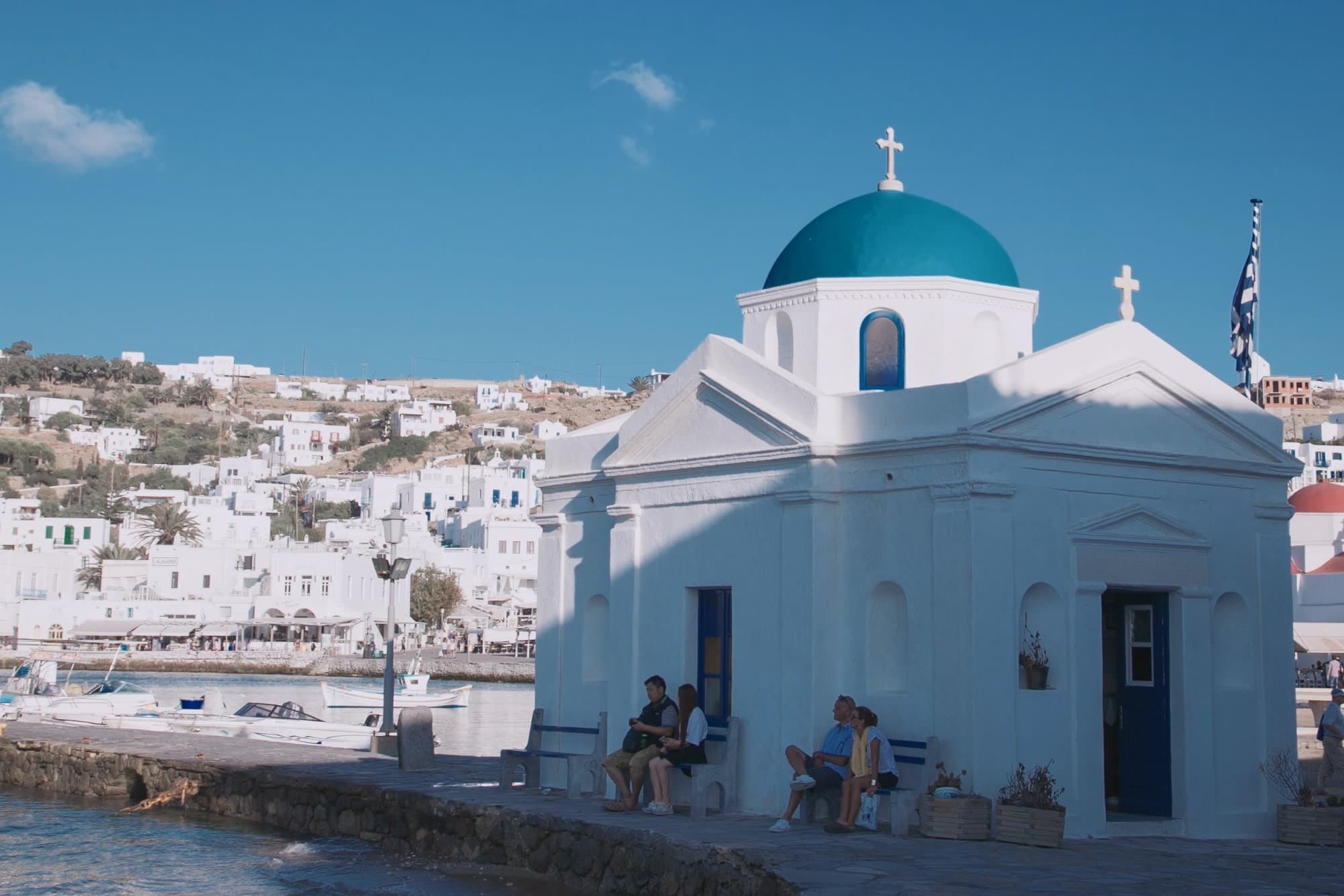 White cathedral under clear blue sky near waterbody