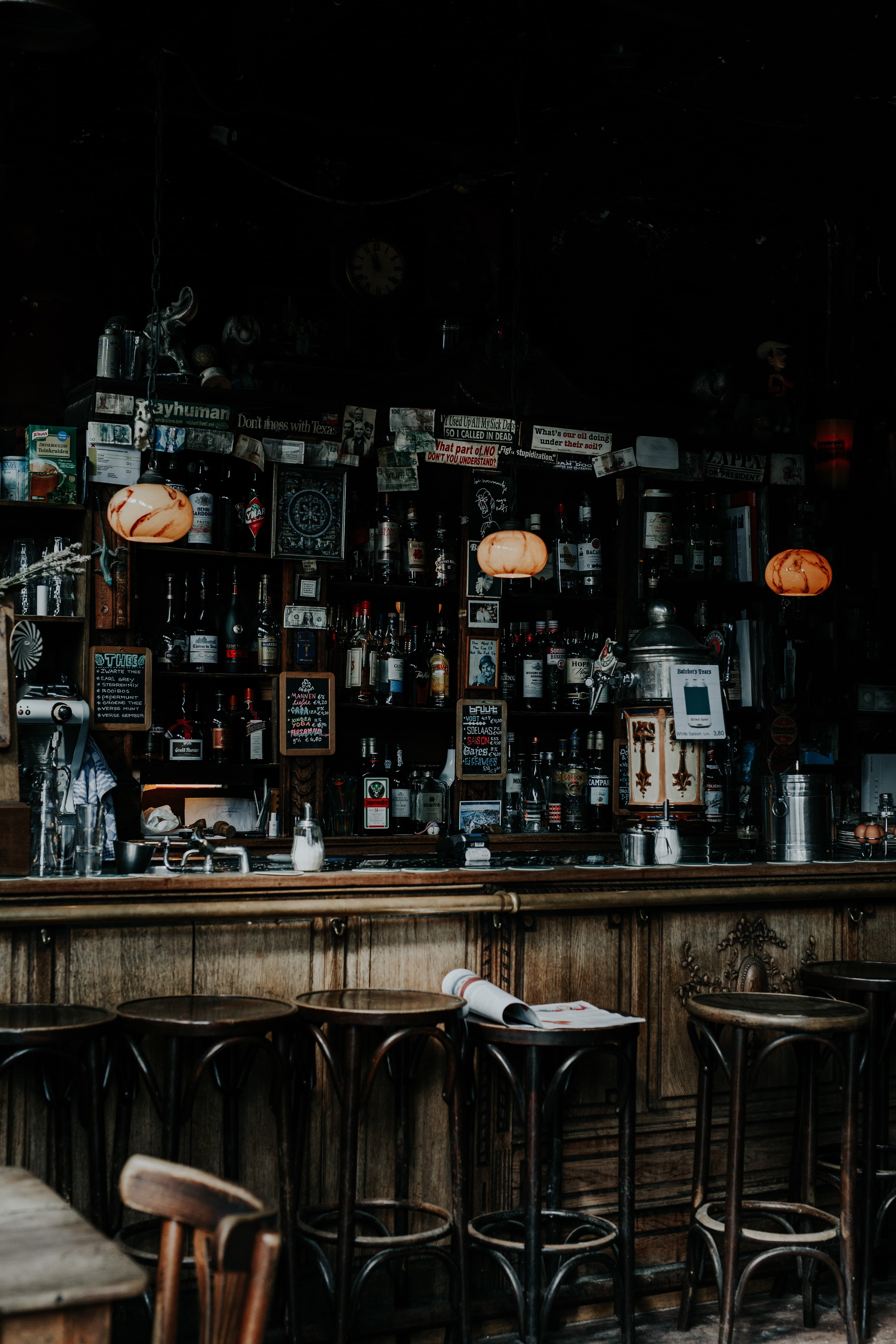 A dark-lit bar with wooden stools in Amsterdam.