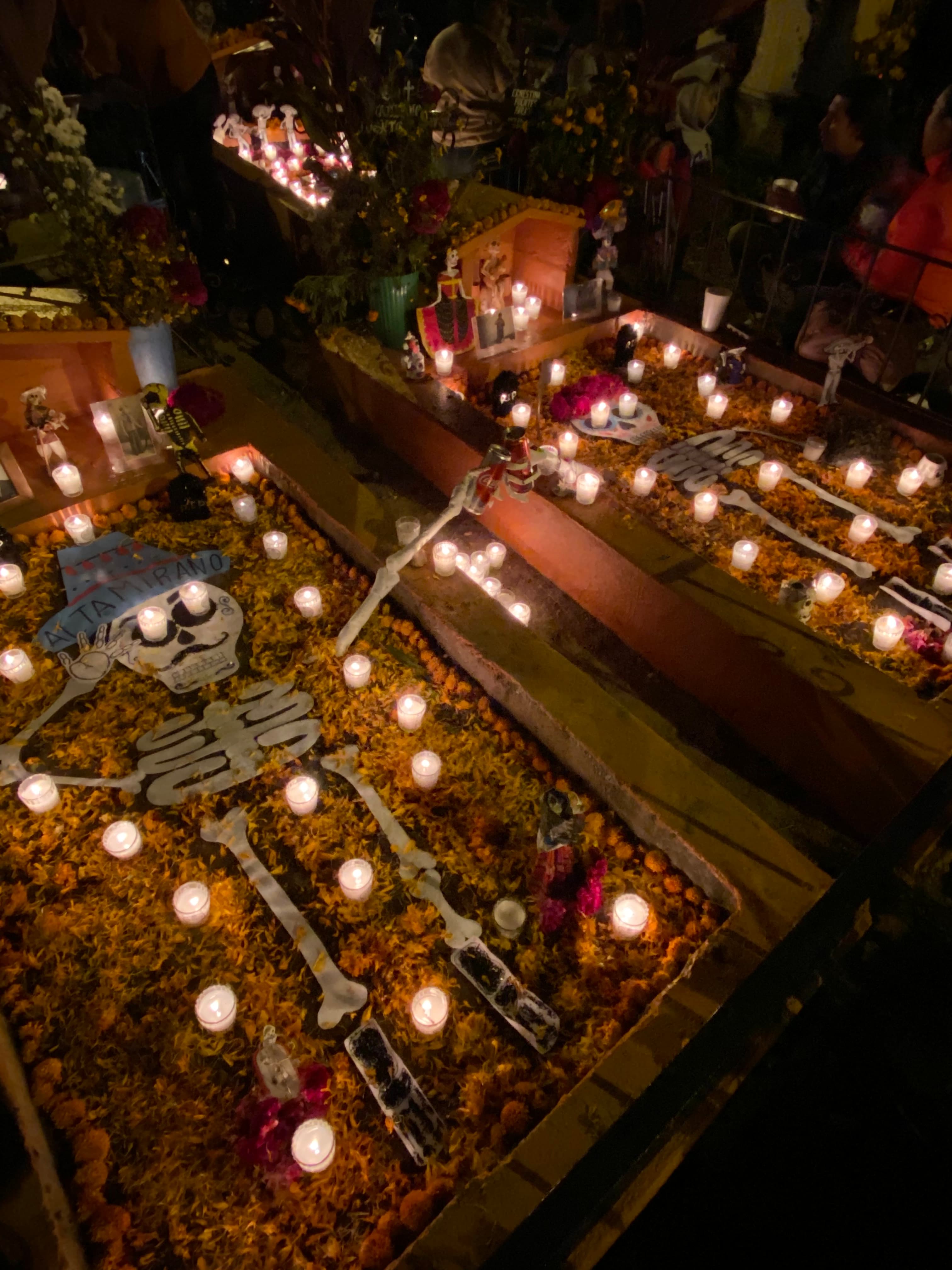 Two fake skeletons laying in a float in a dark, candle-lit room