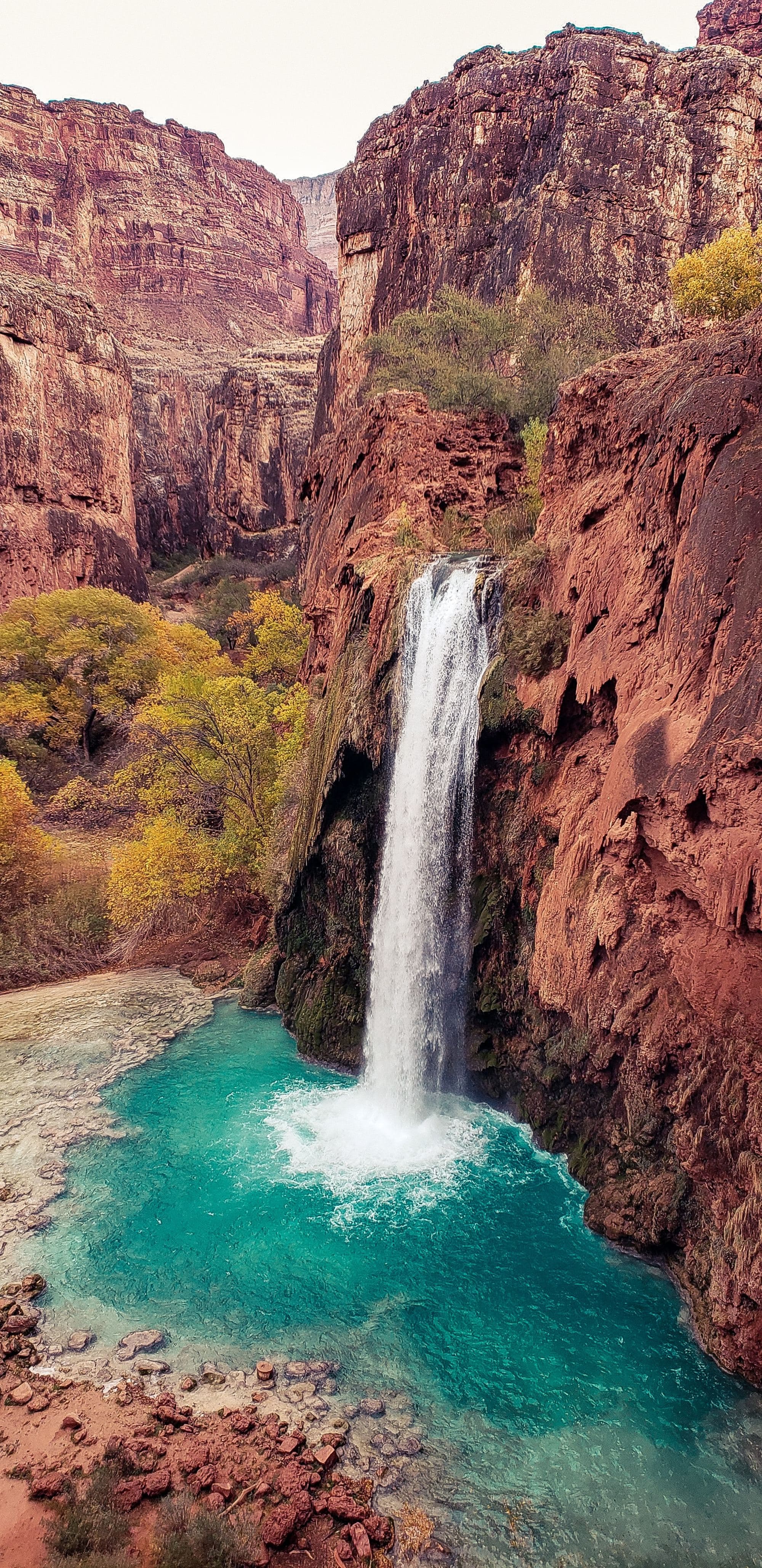 A picture of a waterfall and mountains during daytime.