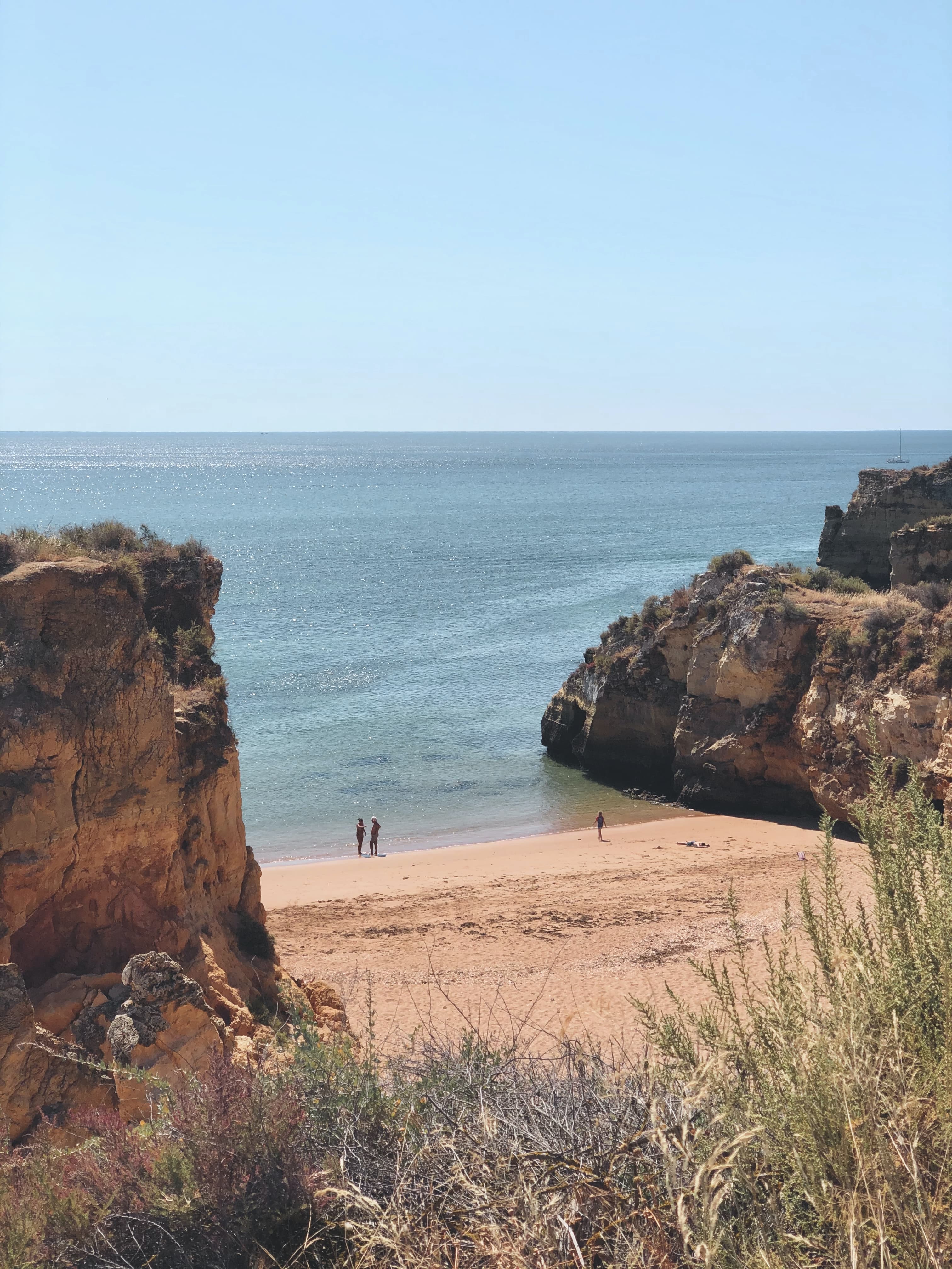 people on beach next to body of water during daytime