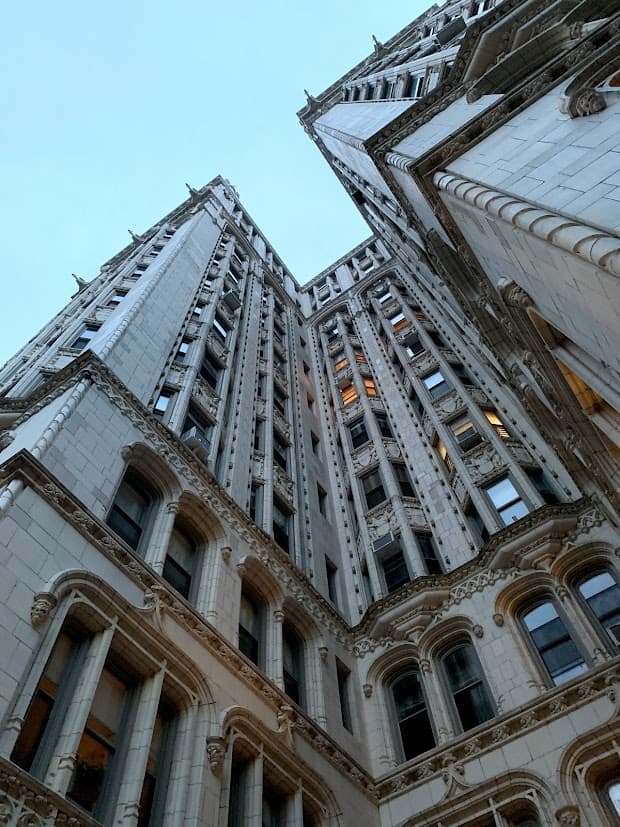 A bottom up view of a stone building with lots of windows in New York City.