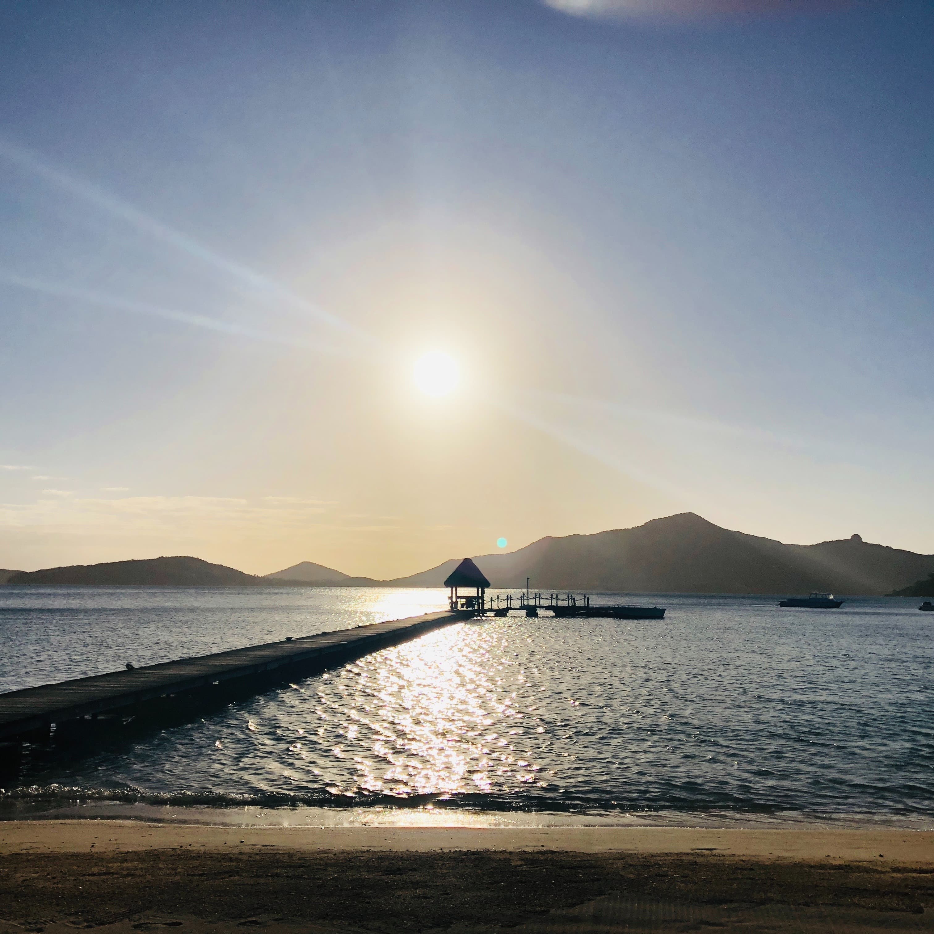 A long deck and beach on a sunny day.