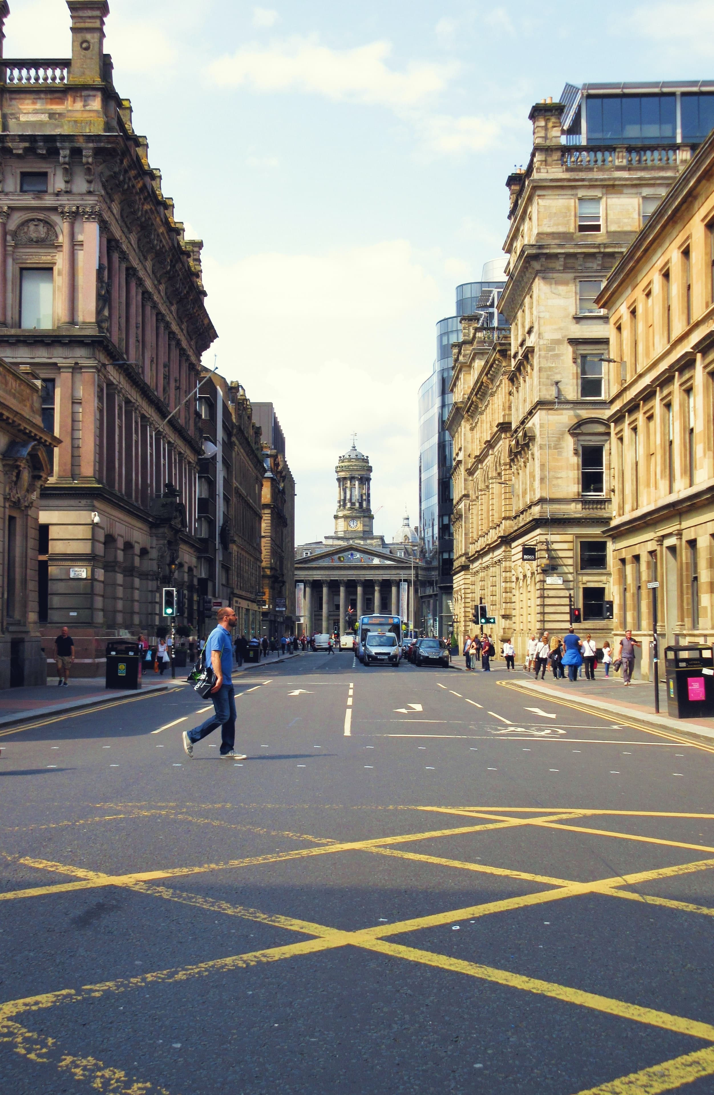 man standing in street next to buildings during daytime