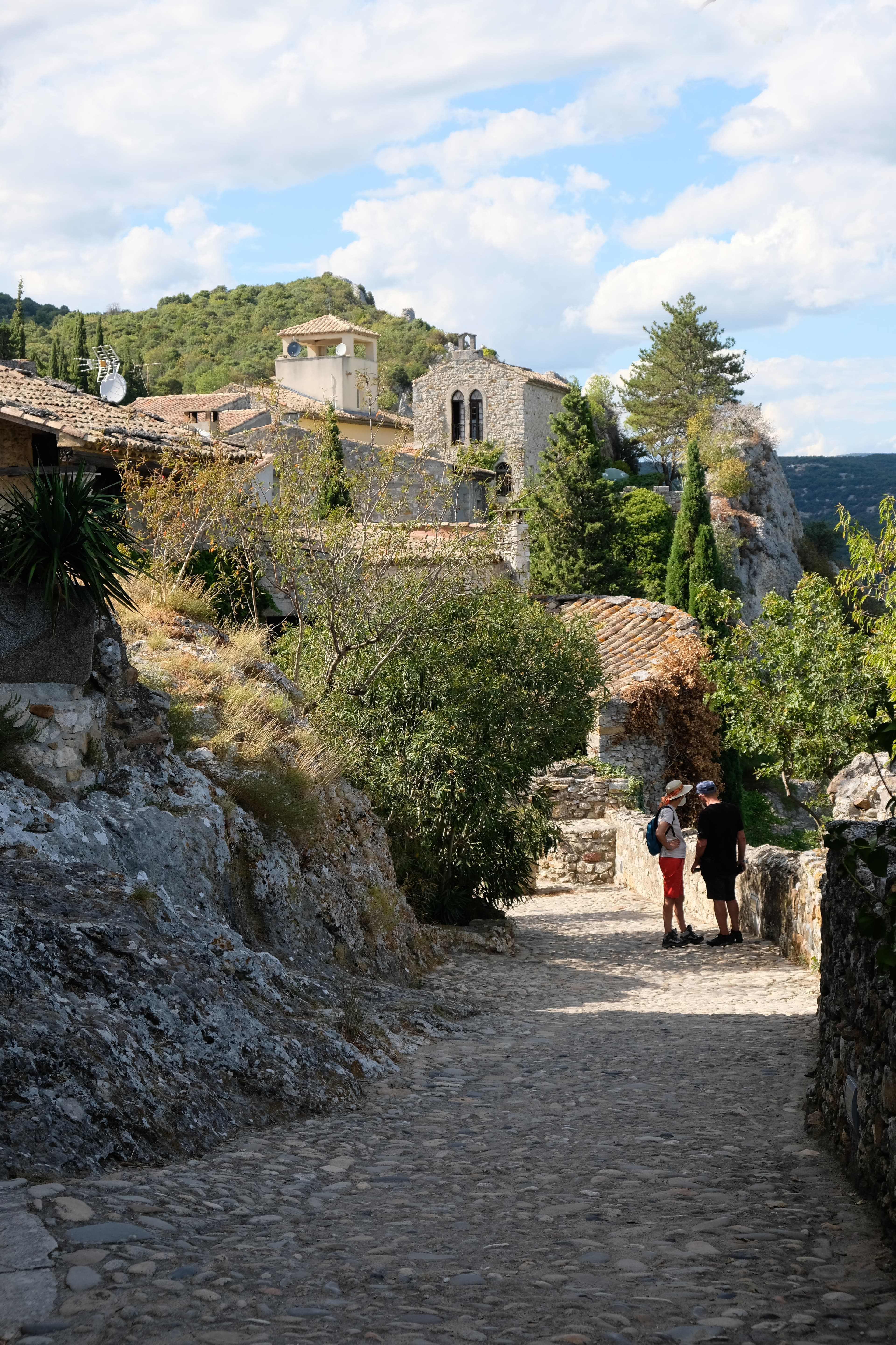 two people standing next to stone wall during daytime