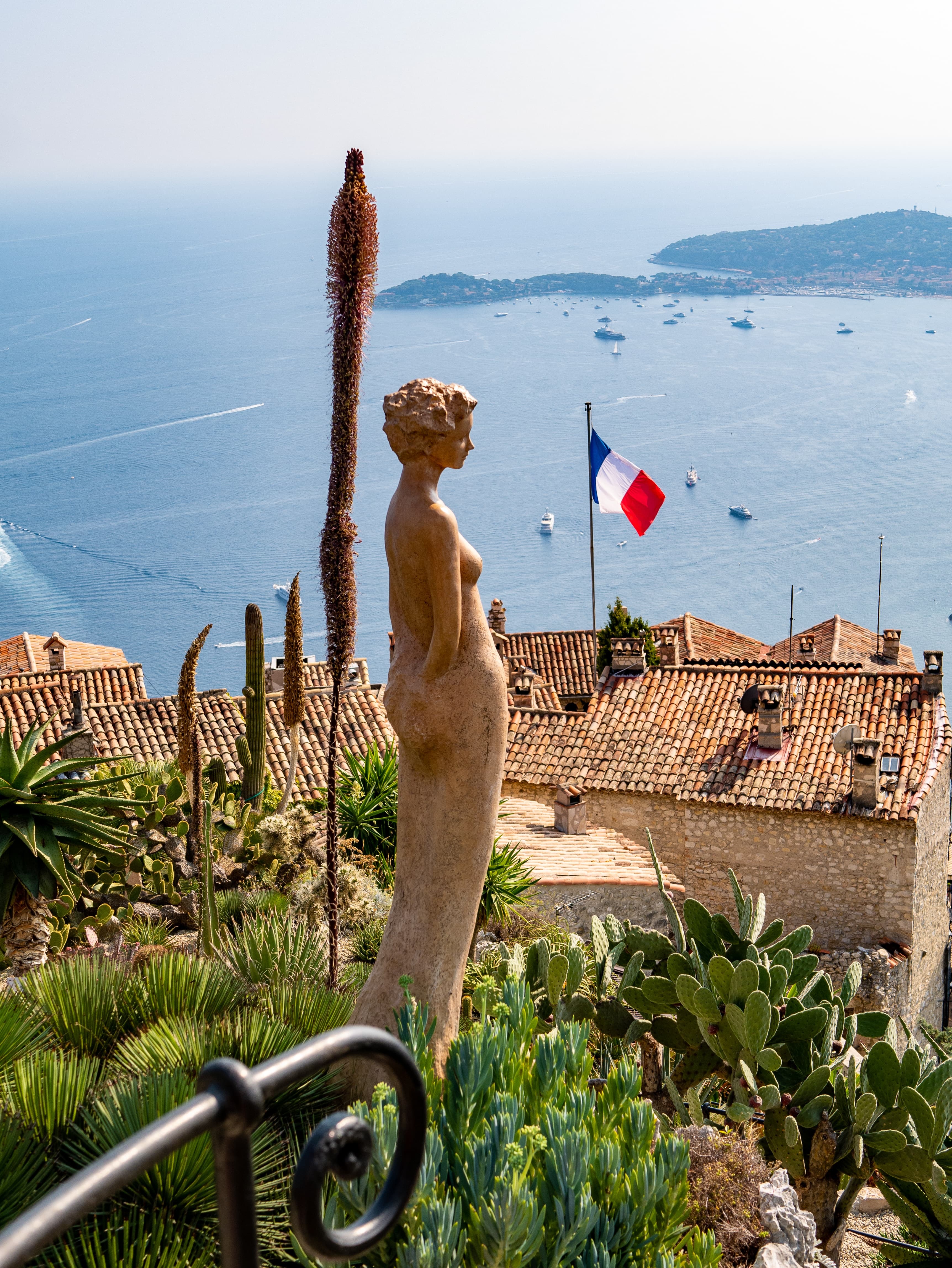 A woman brown statue with France Flag in the background
