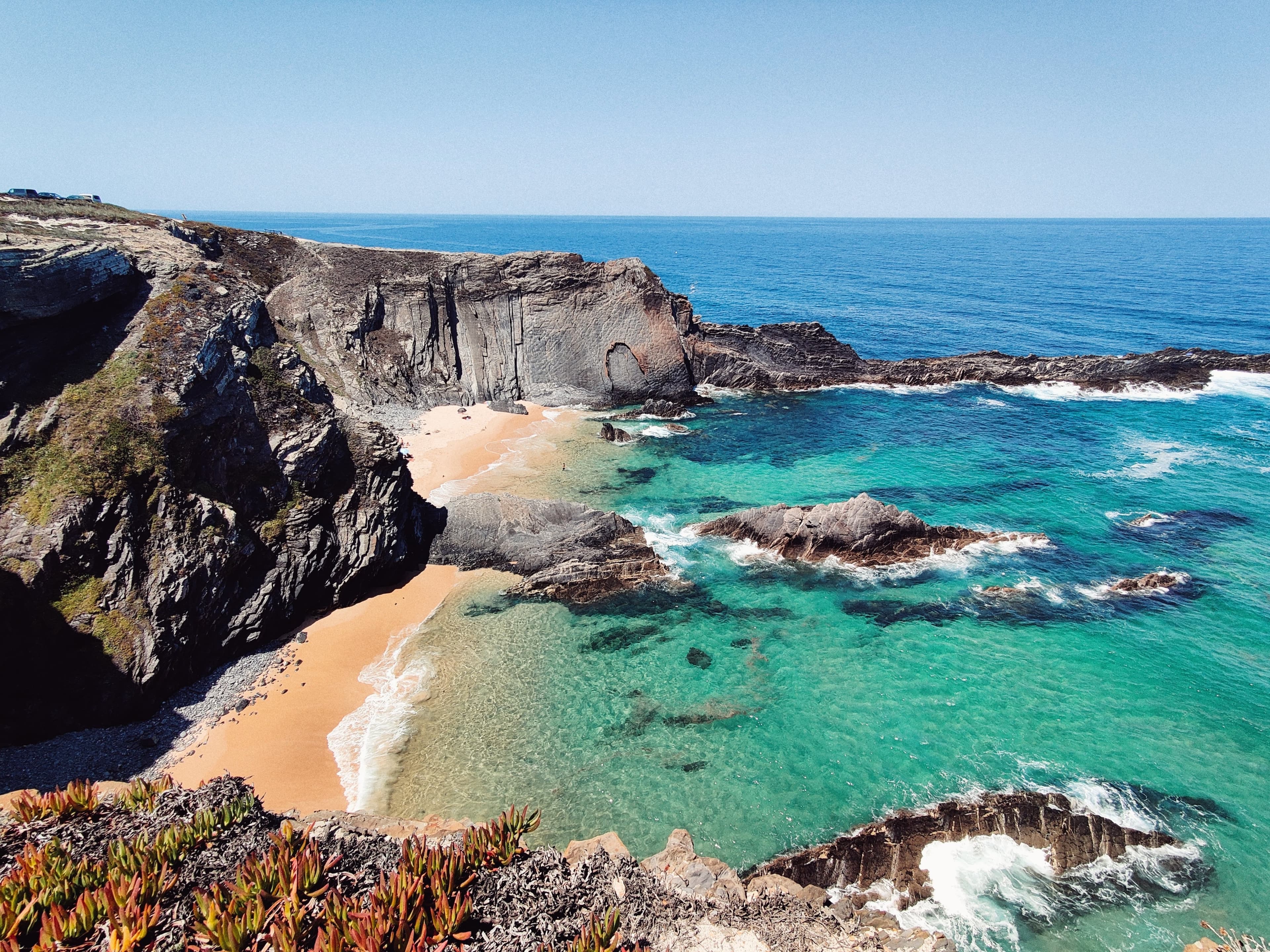 blue waters next to rocky coastline during daytime