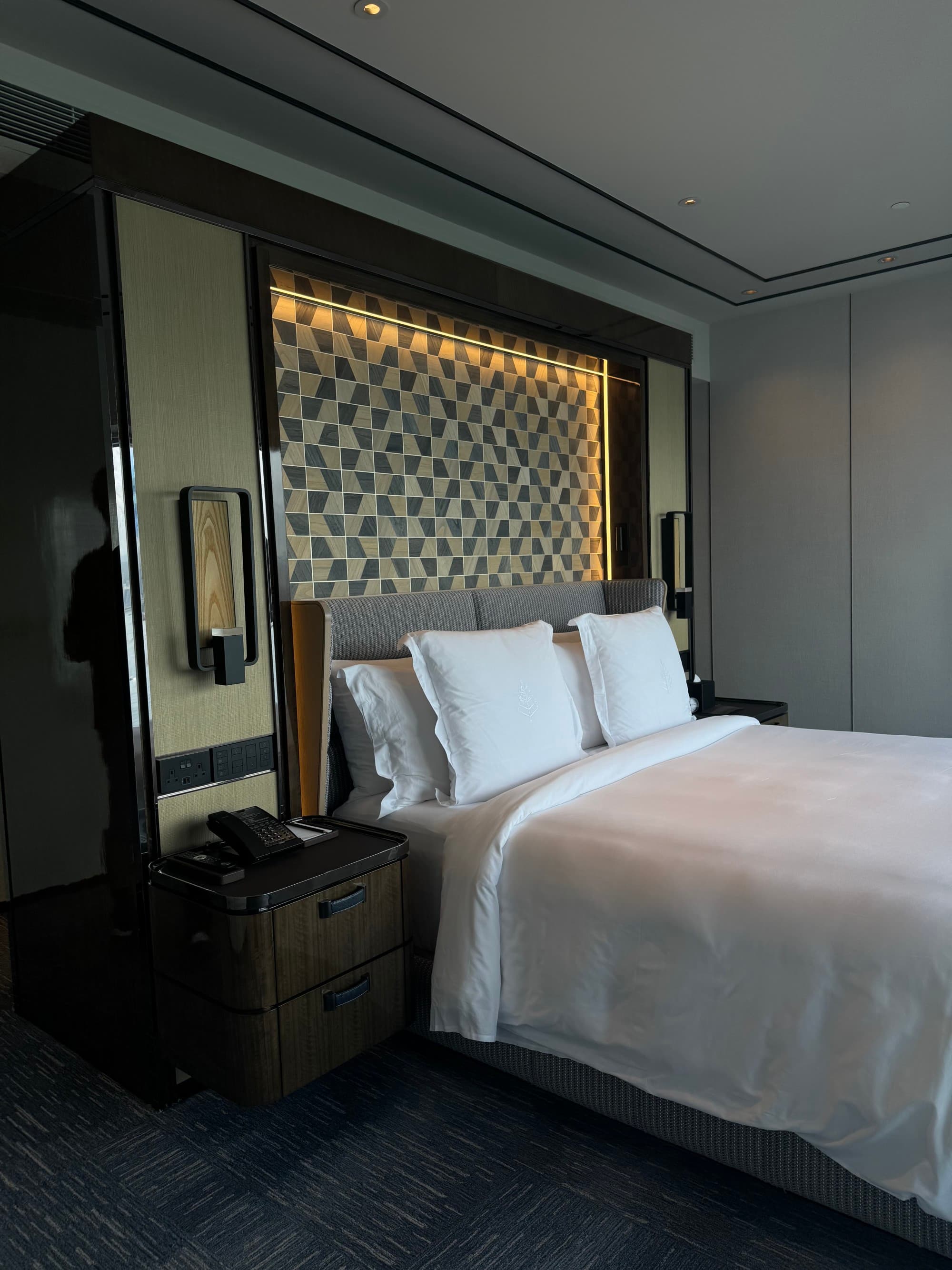 The Superior Harbour View Suite perched on the hotel's upper floors features a large comfortable bed and modern furnishings.