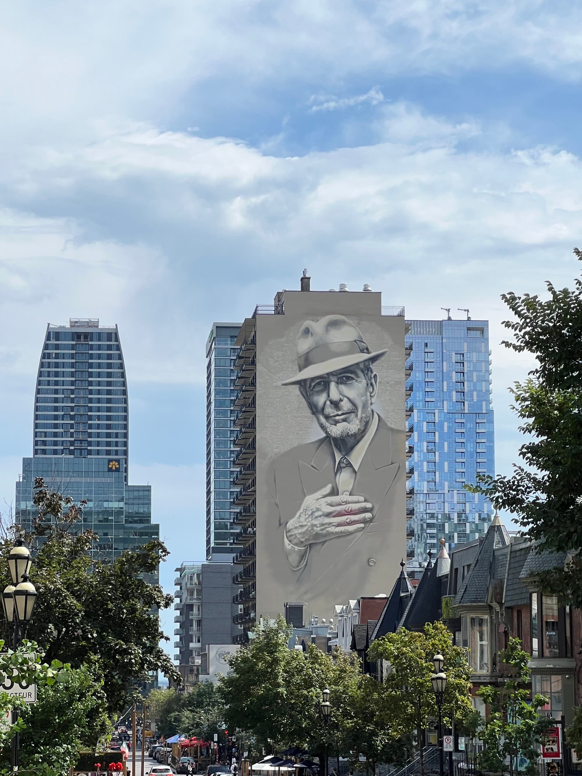 Downtown skycrapers reaching toward the sky on a clear day dotted with clouds.