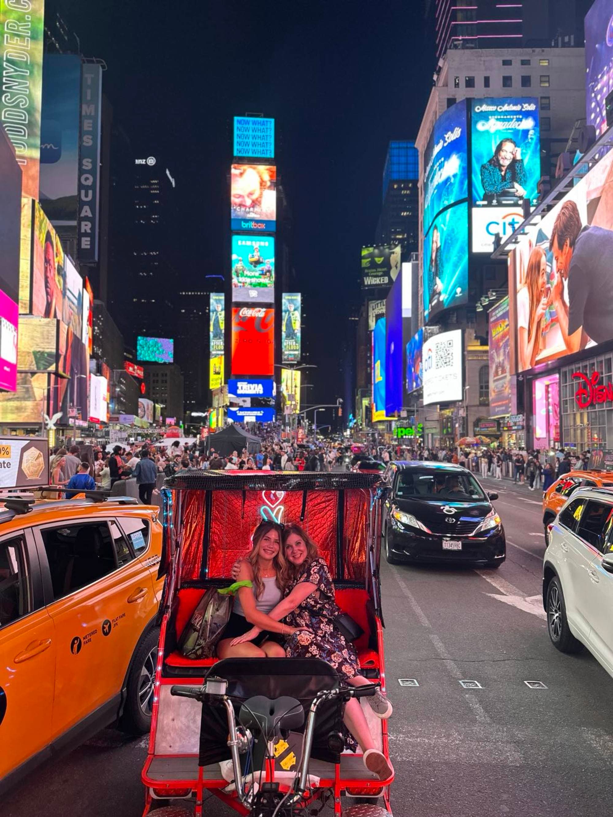 Amidst the vibrant lights of Times Square, a Tuk-Tuk carries its passengers through the city’s electric pulse.