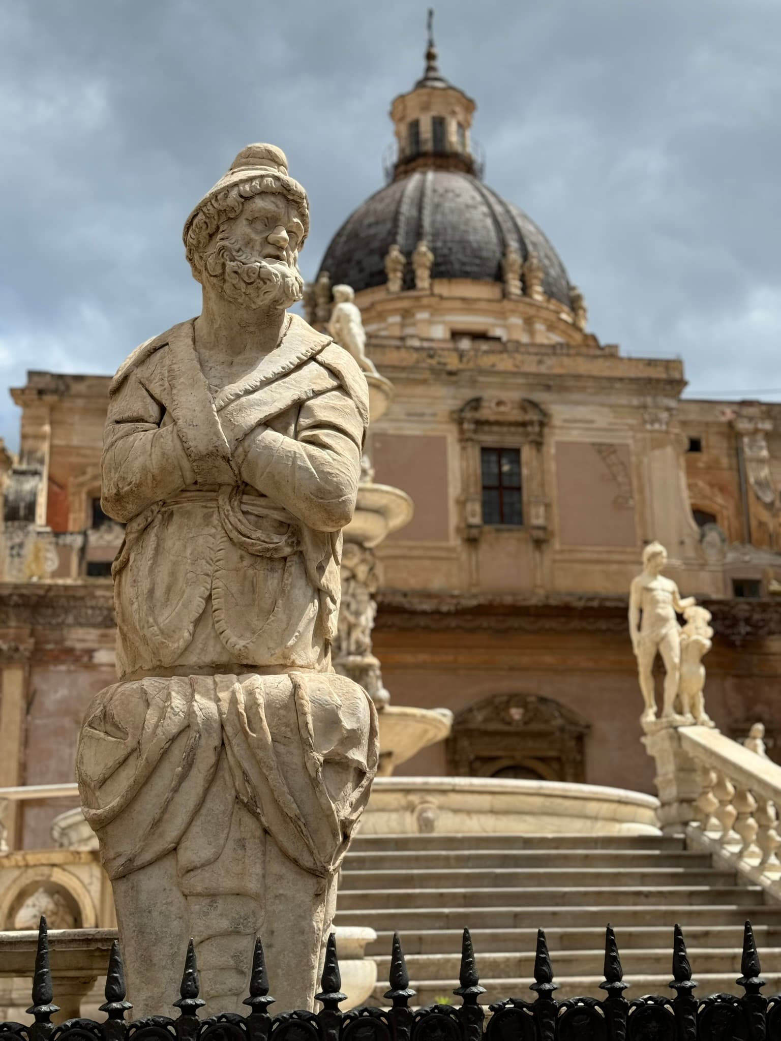 A statue of a man in front of an ancient building