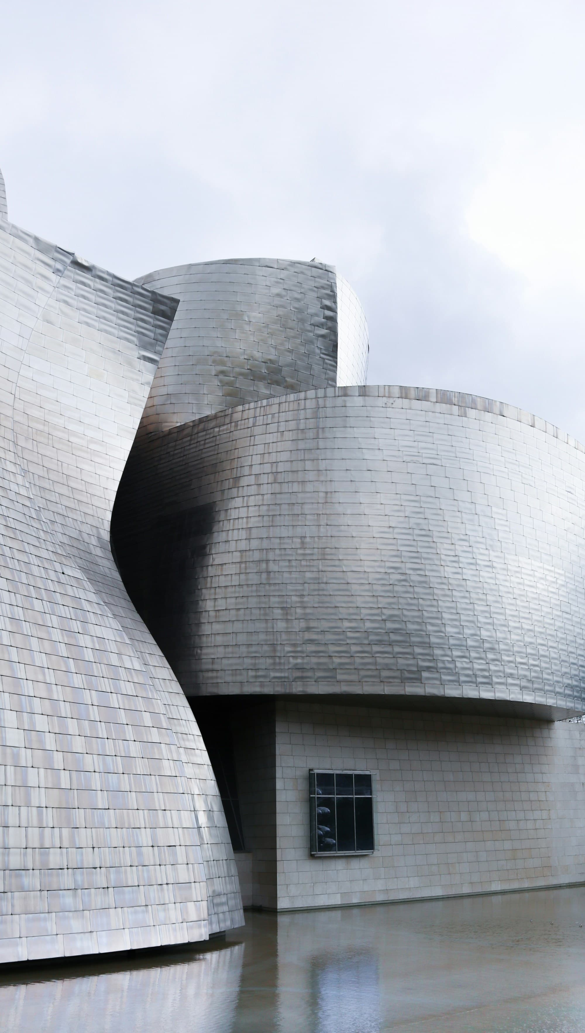 A close-up shot of the curvy architecture of the exterior of the Guggenheim Museum in Bilboa, Spain.