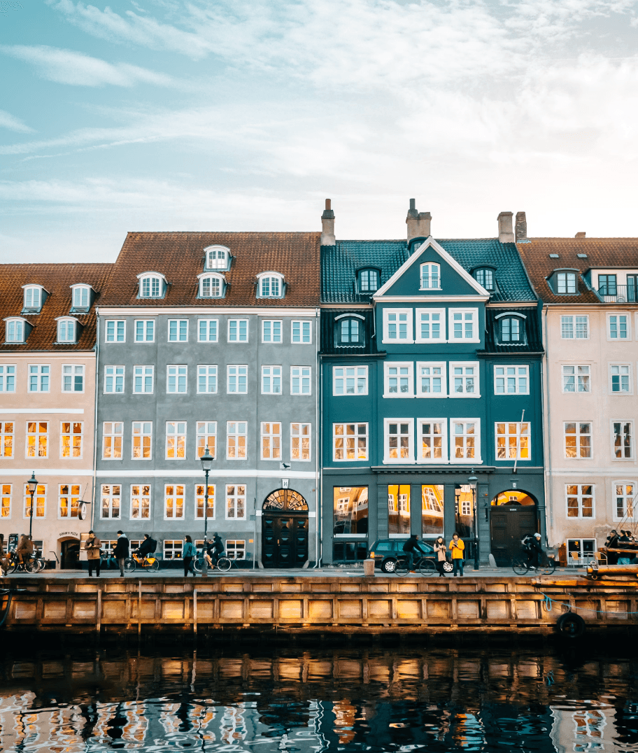 An array of colorful buildings in Copenhagen lined up in front of a river.
