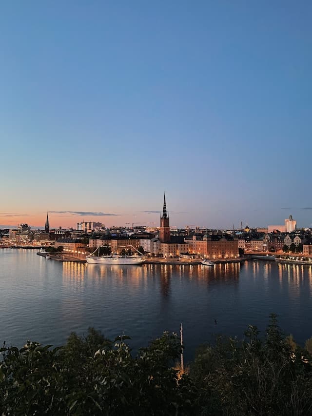 A view of a city next to a body of water at dusk.