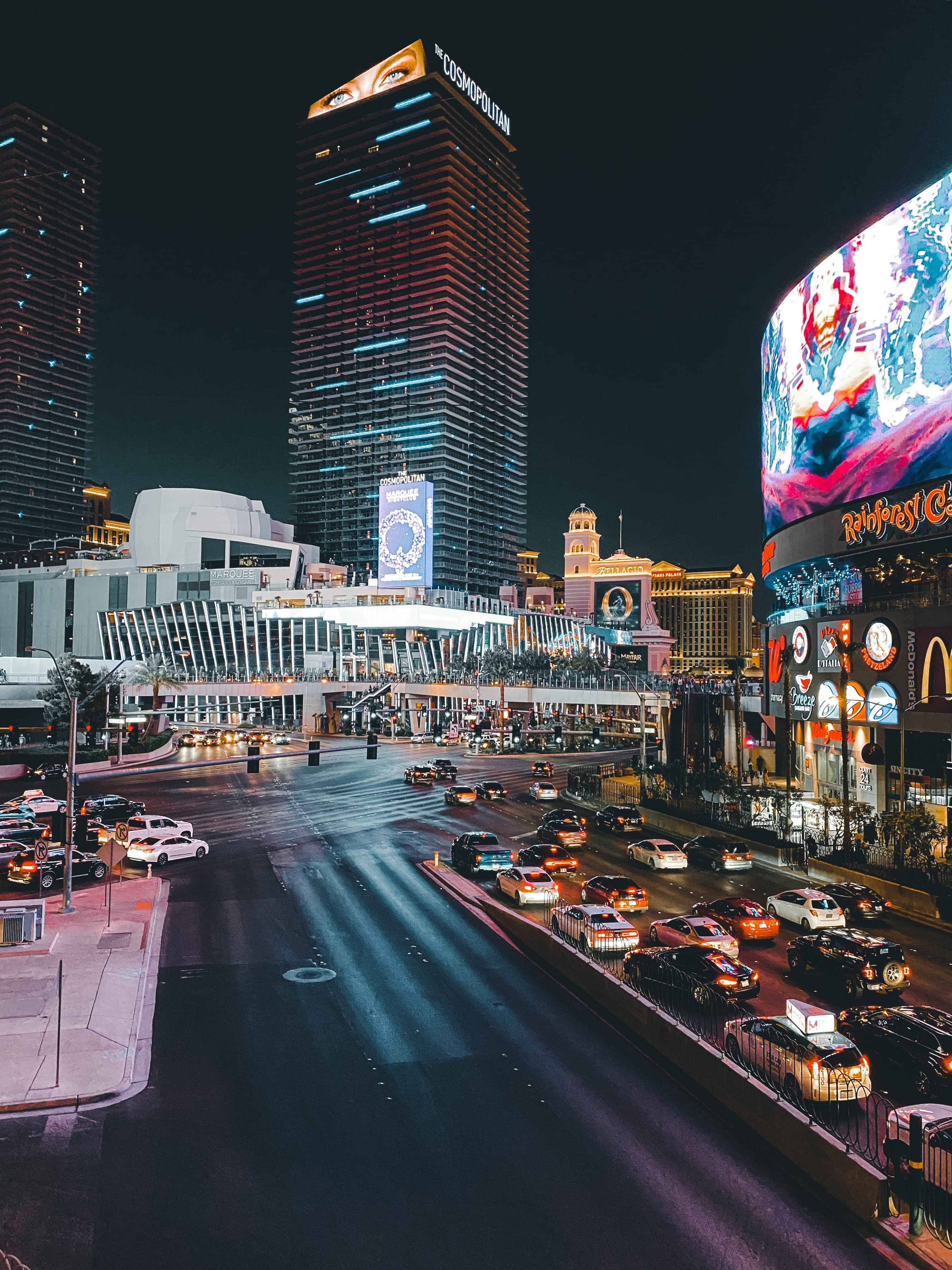 Street with cars lined with tall buildings during nighttime