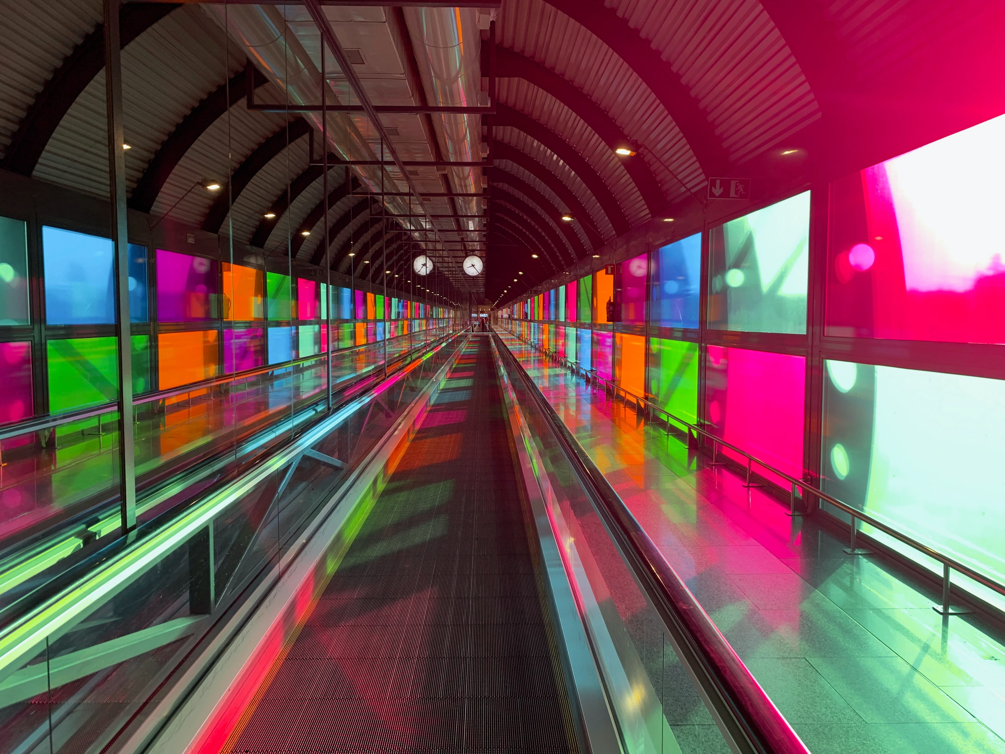 Walkway surrounded by pink, green, orange and blue windows in Madrid