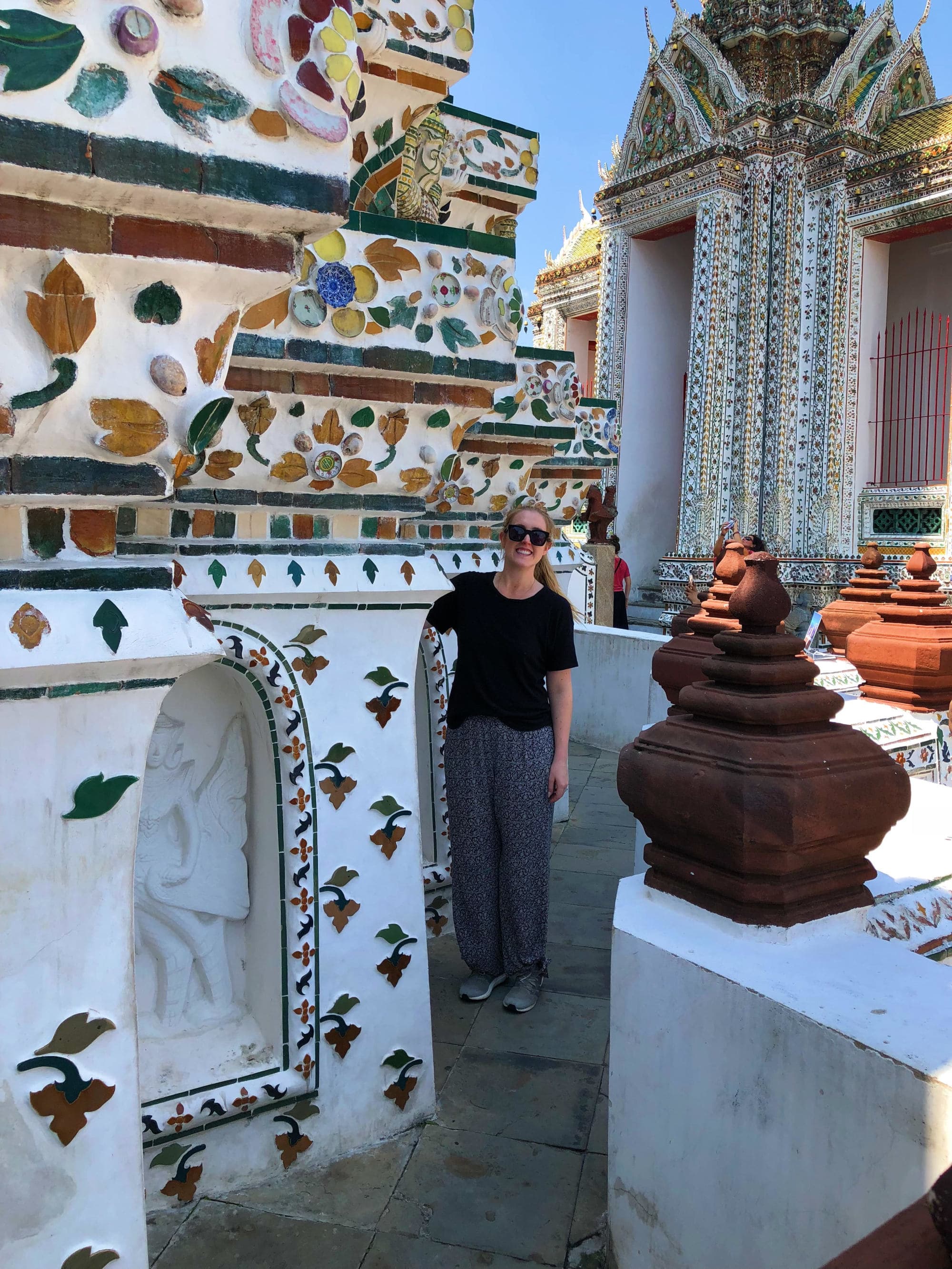 A woman posing amidst a mazy of tiled walls.