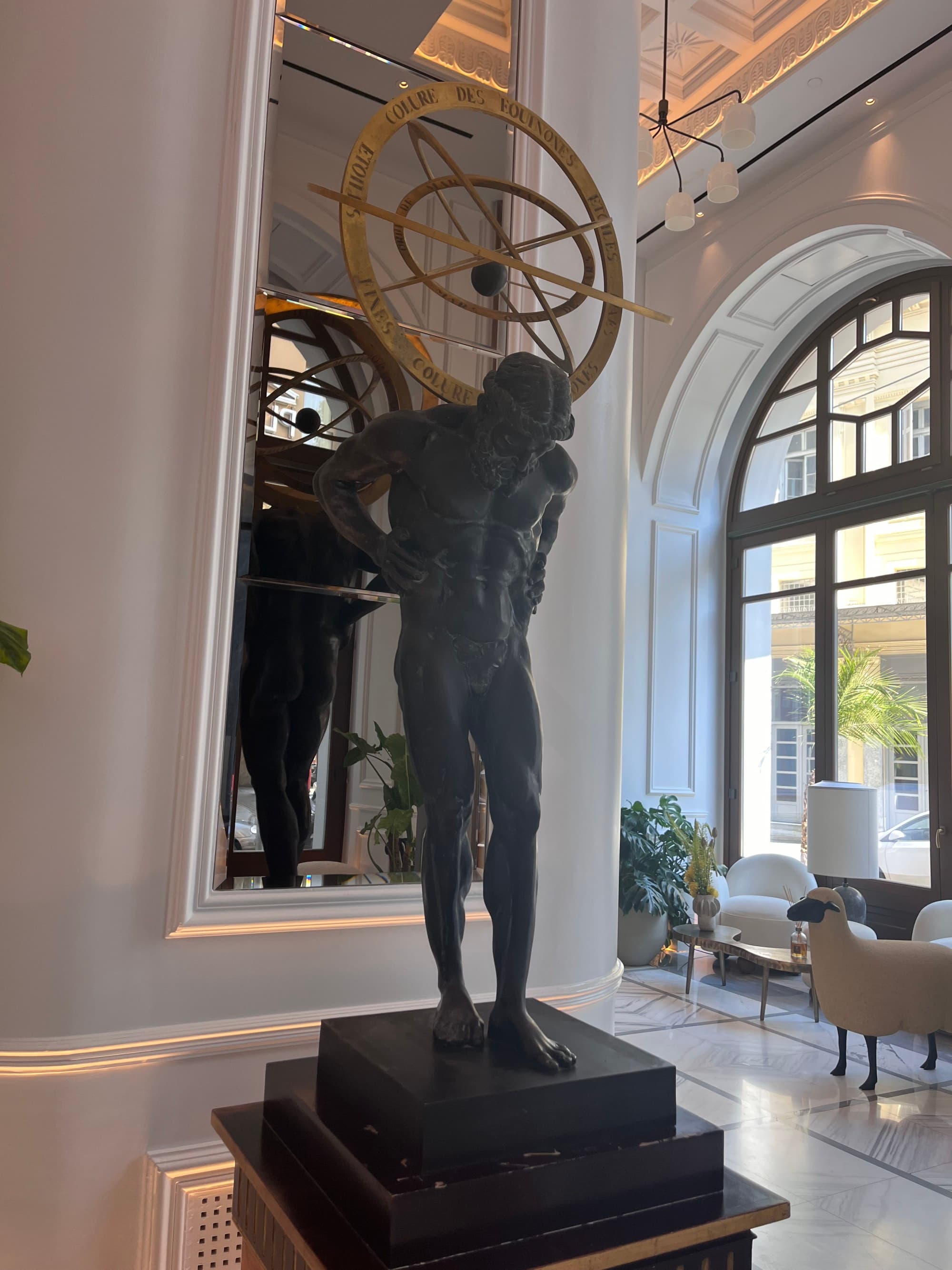 Hotel interior boasts high ceilings and sculpture in the lobby.