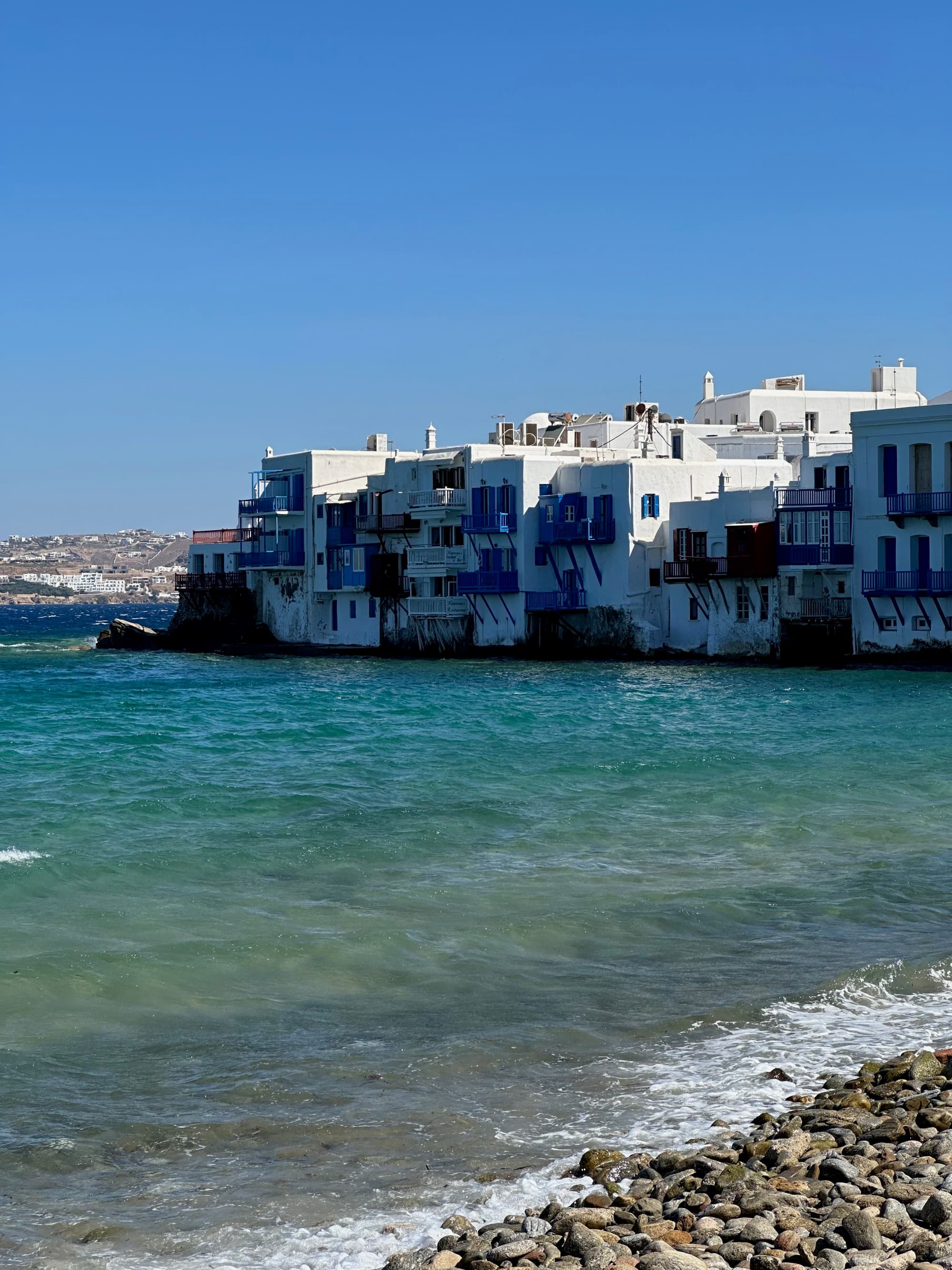 White buildings along the shore in Mykonos - Kristyne Wada