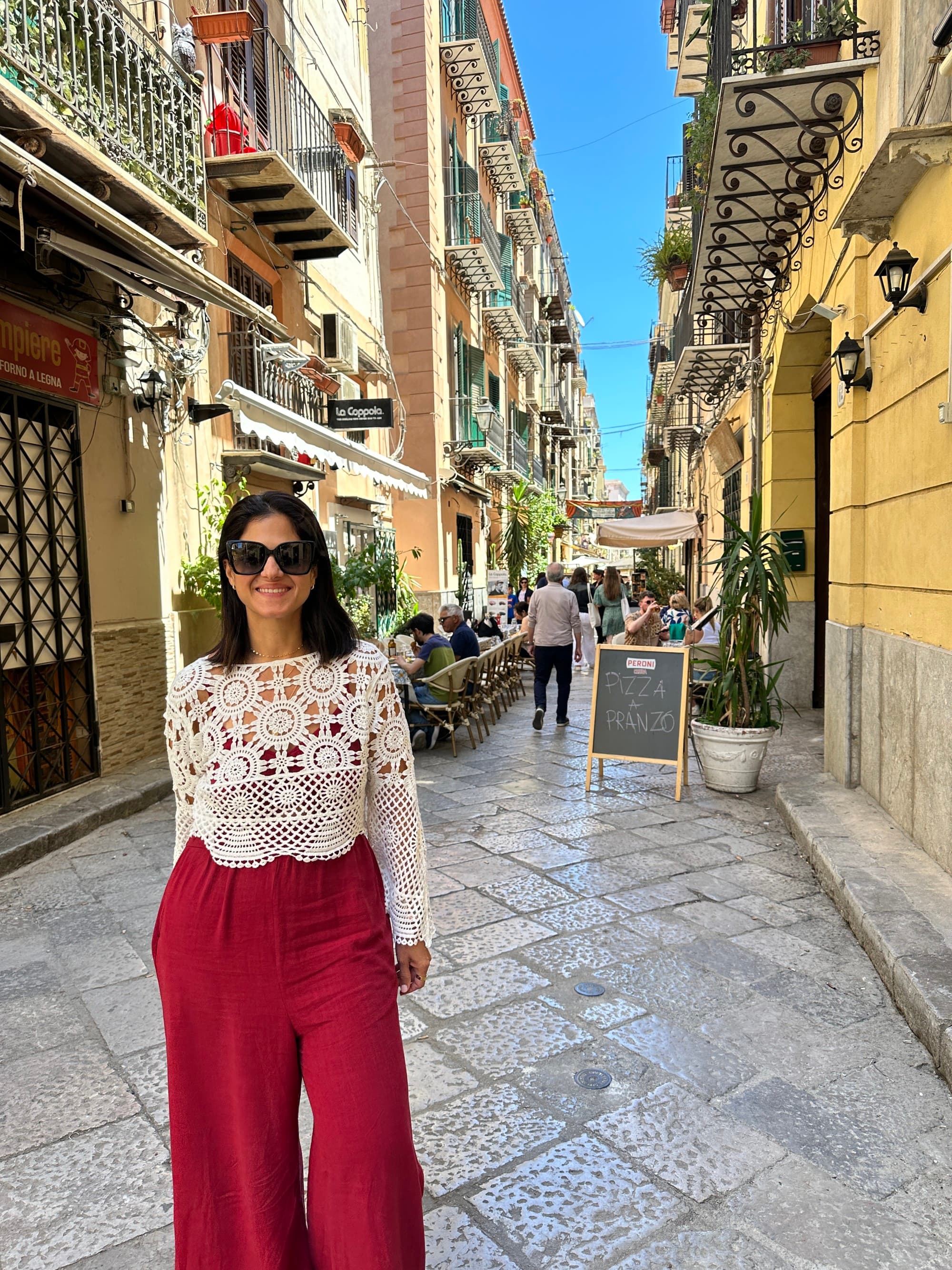 Advisor stands on a narrow Italian city street.