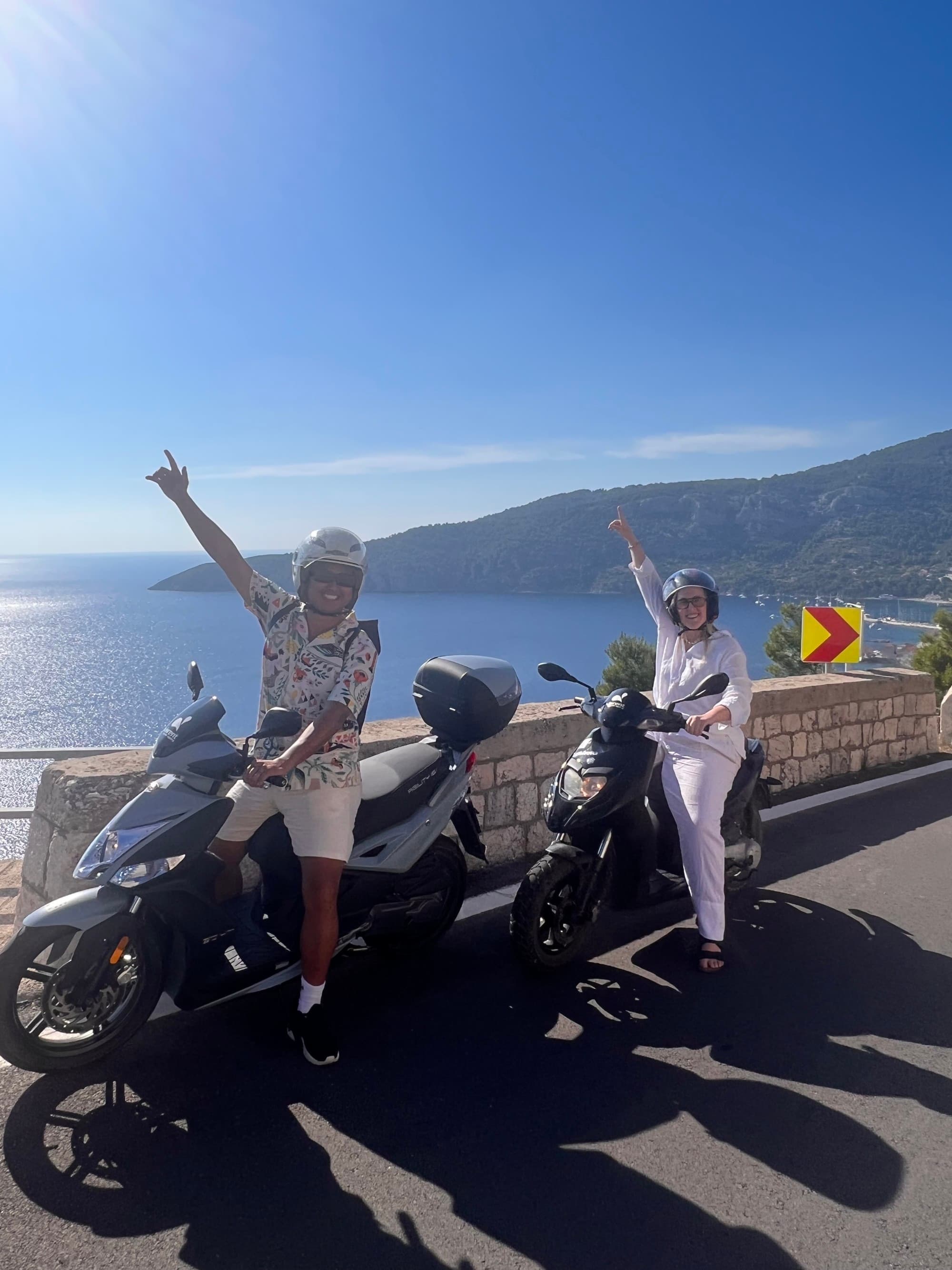 Couple posing on motor scooters.
