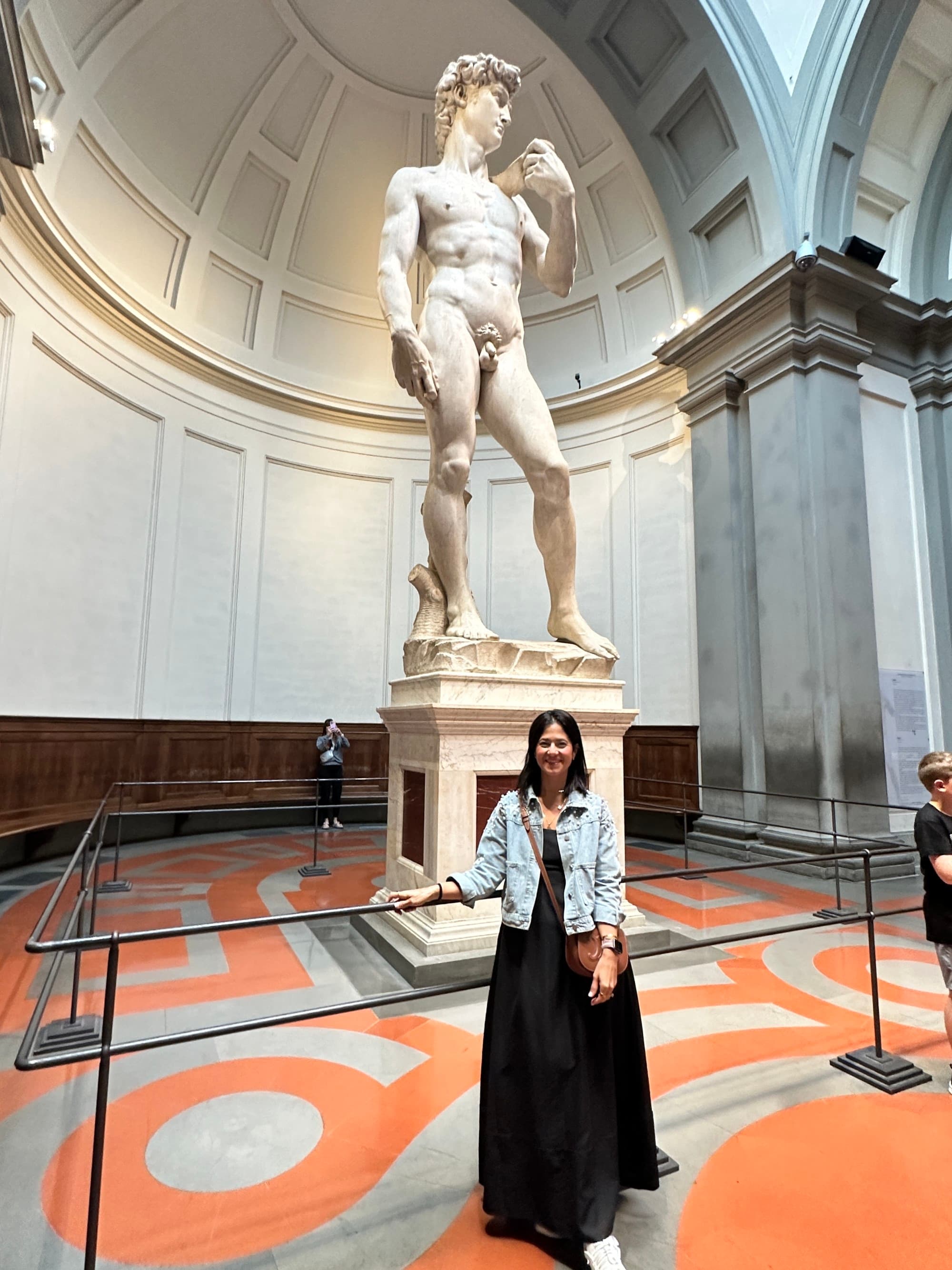 Advisor poses in front of the statue of David.