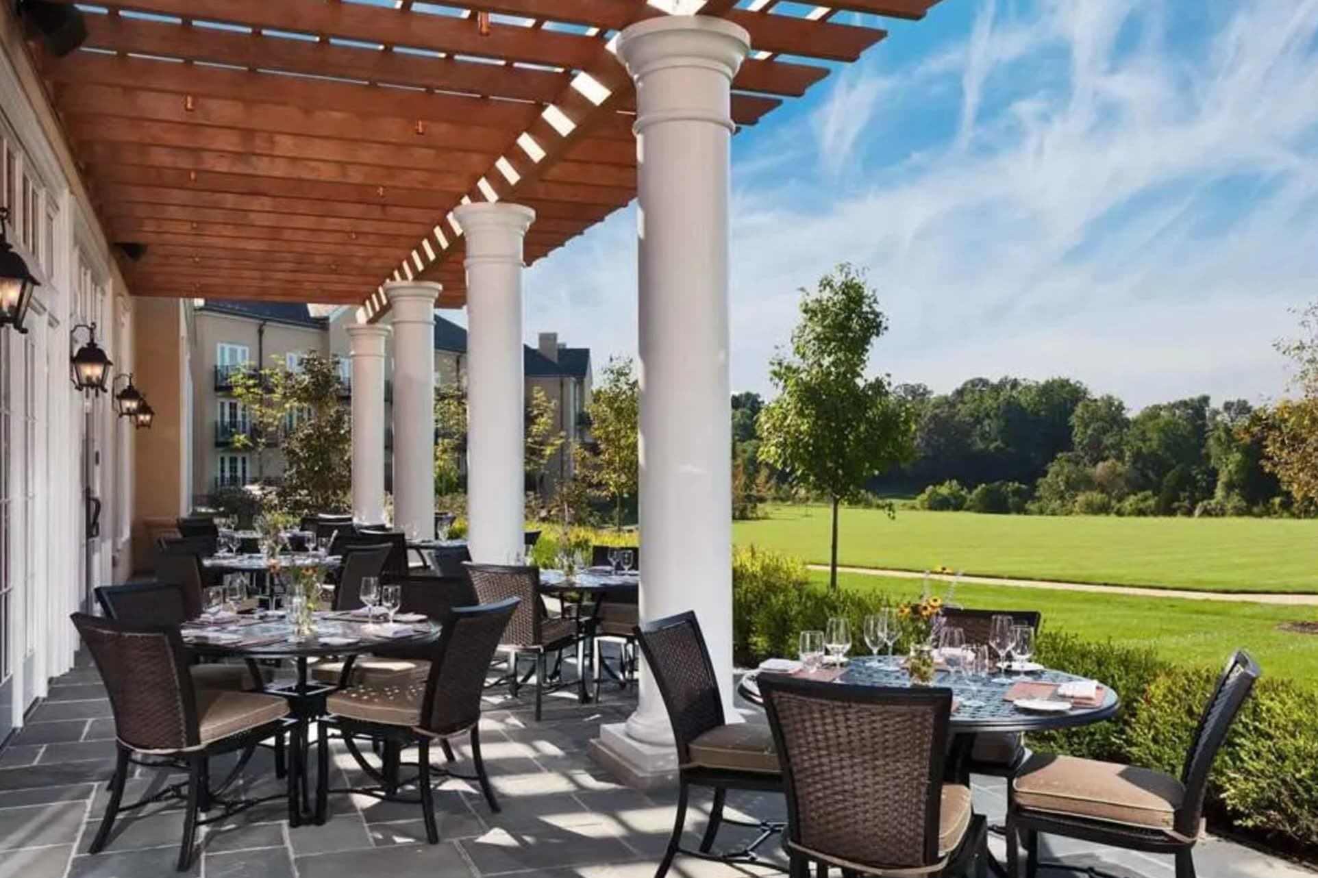 furnished dining terrace looking out onto green lawn and woods