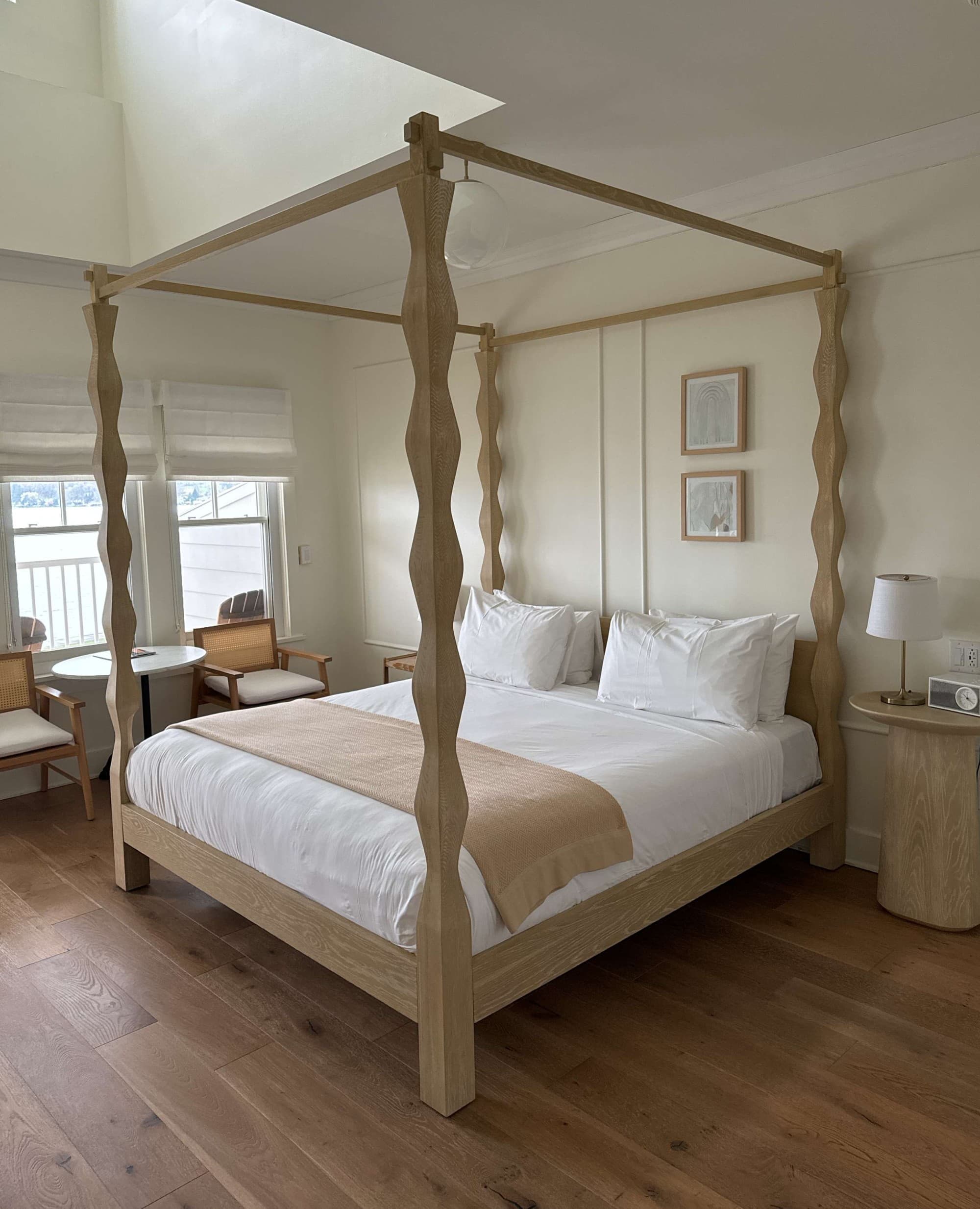 King room with a large white bed and wood floors - Noelle Rudloff