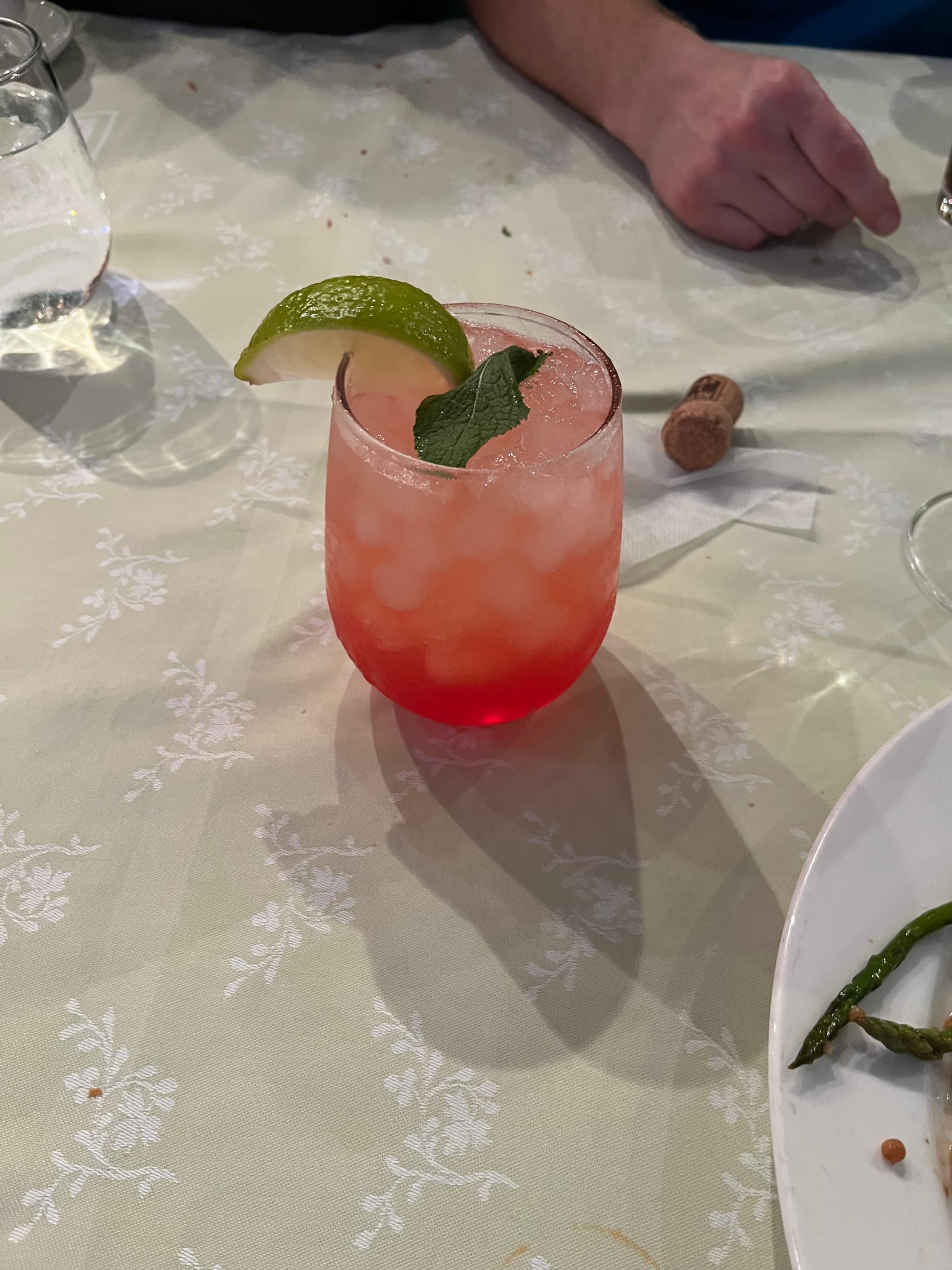 A tropical and refreshing cocktail, topped with a lime wedge and a mint leaf.