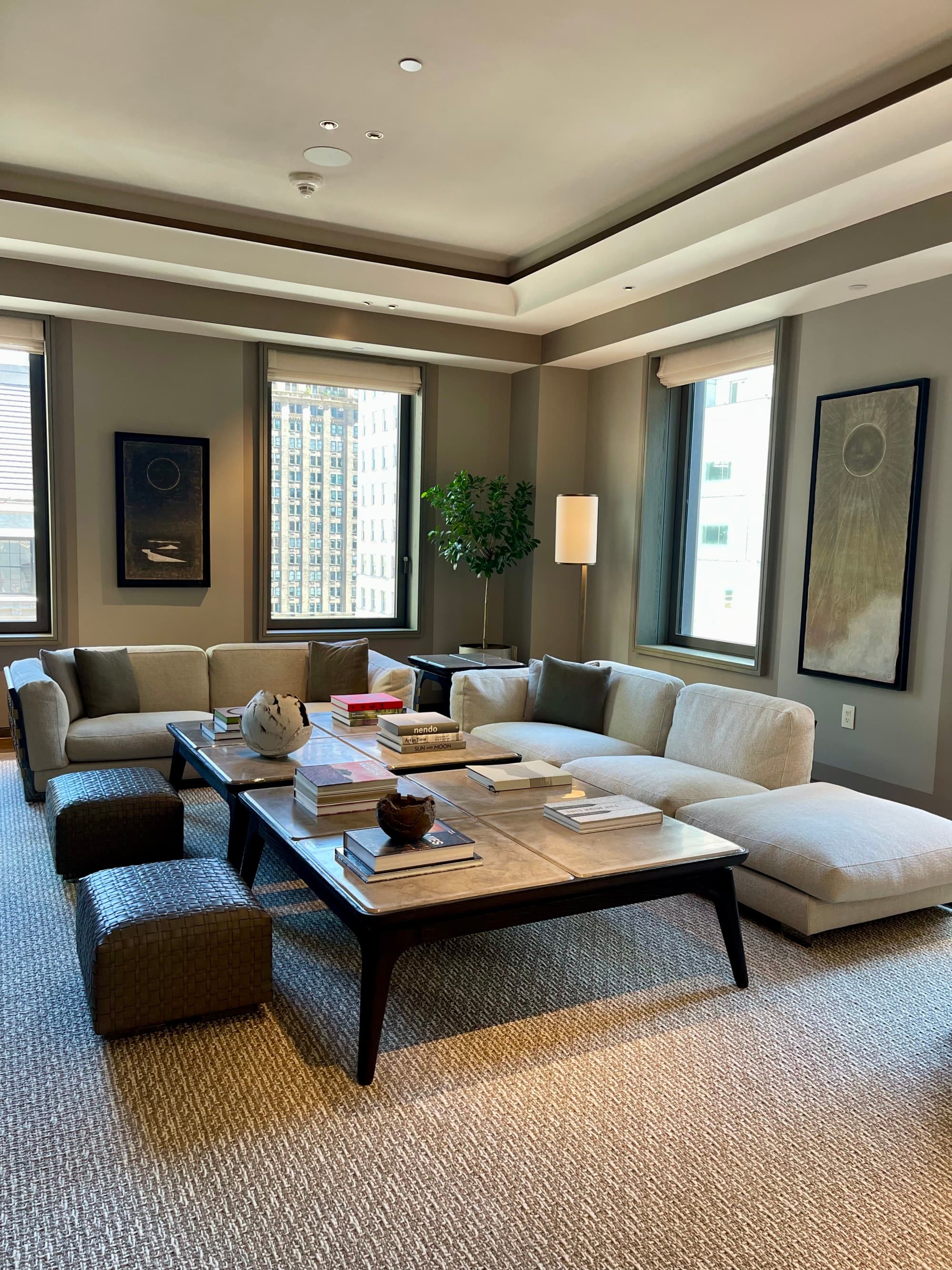 A lounge area in the hotel, with low-to-the-ground furniture, muted tones and a sleek, modern design.