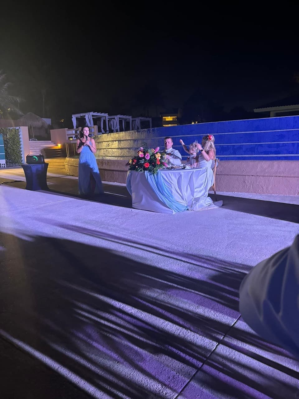 The bride and groom enjoying themselves at their wedding dinner and table, under lavender, l.e.d. lighting.