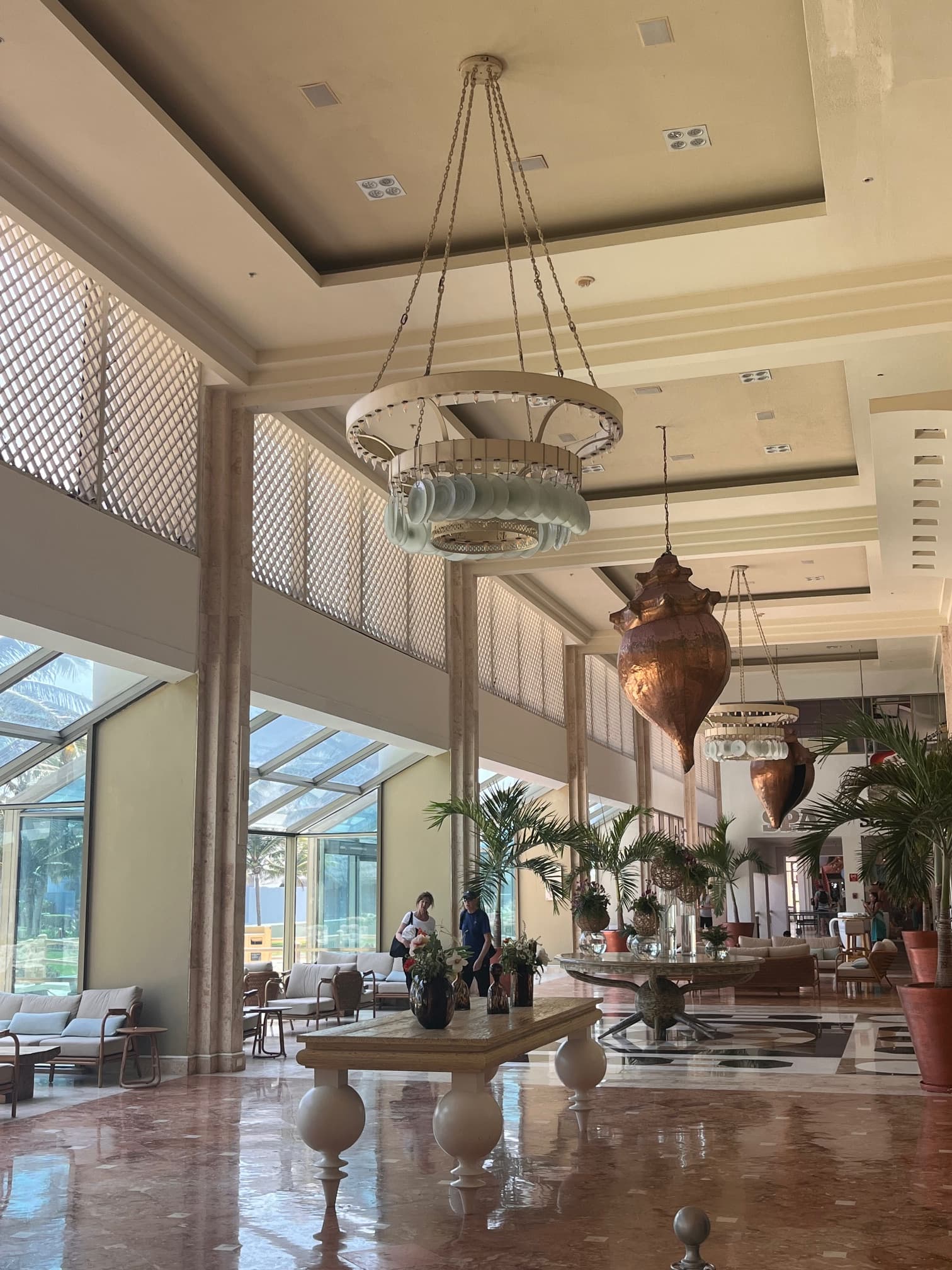 The luxurious and spacious lobby of the Iberostar hotel, decorated with muted tones, and eclectic furnishings.