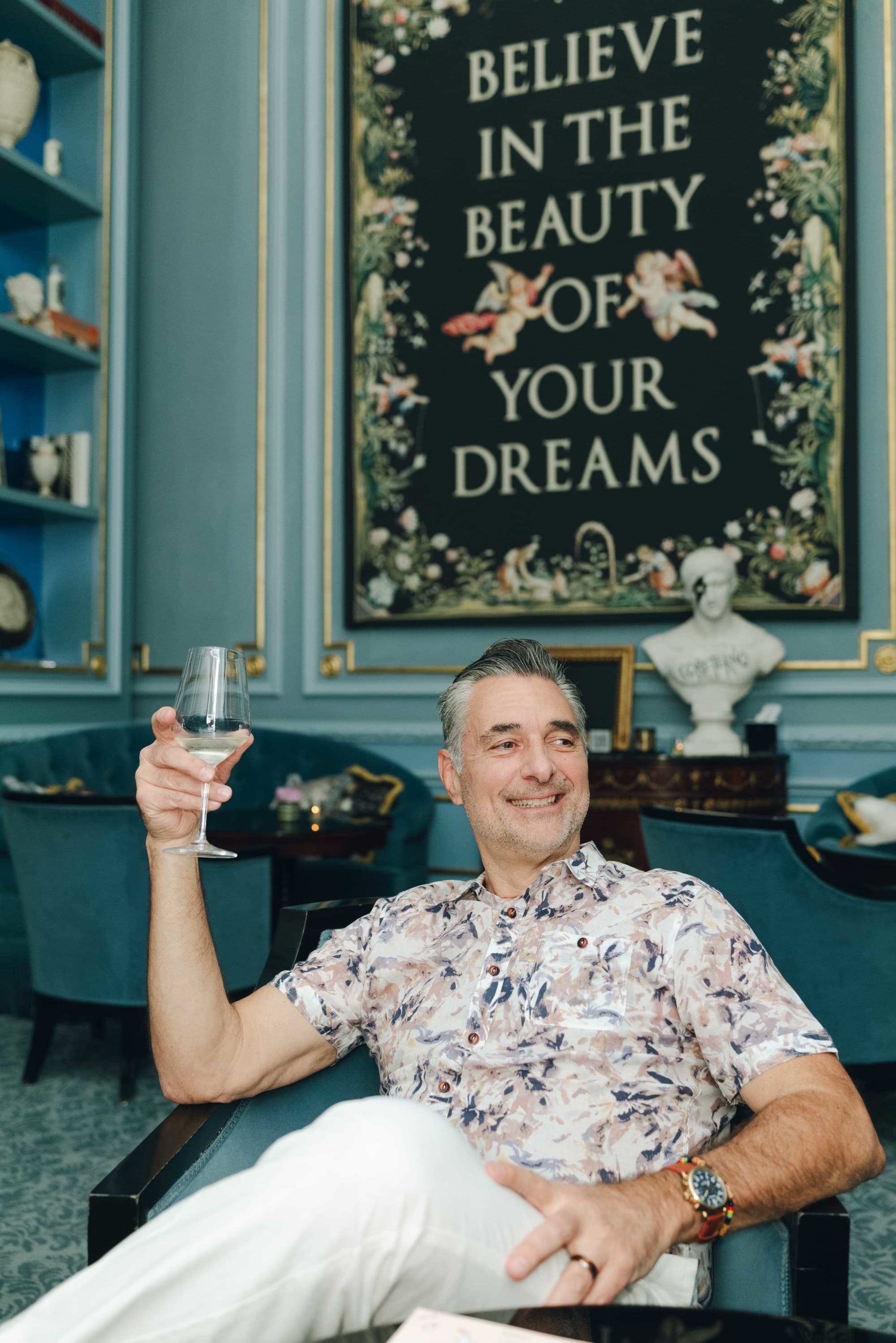 A man sitting in a chair holding a drink