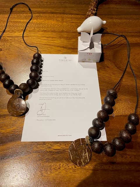 A piece of paper on a table with beaded necklaces on top