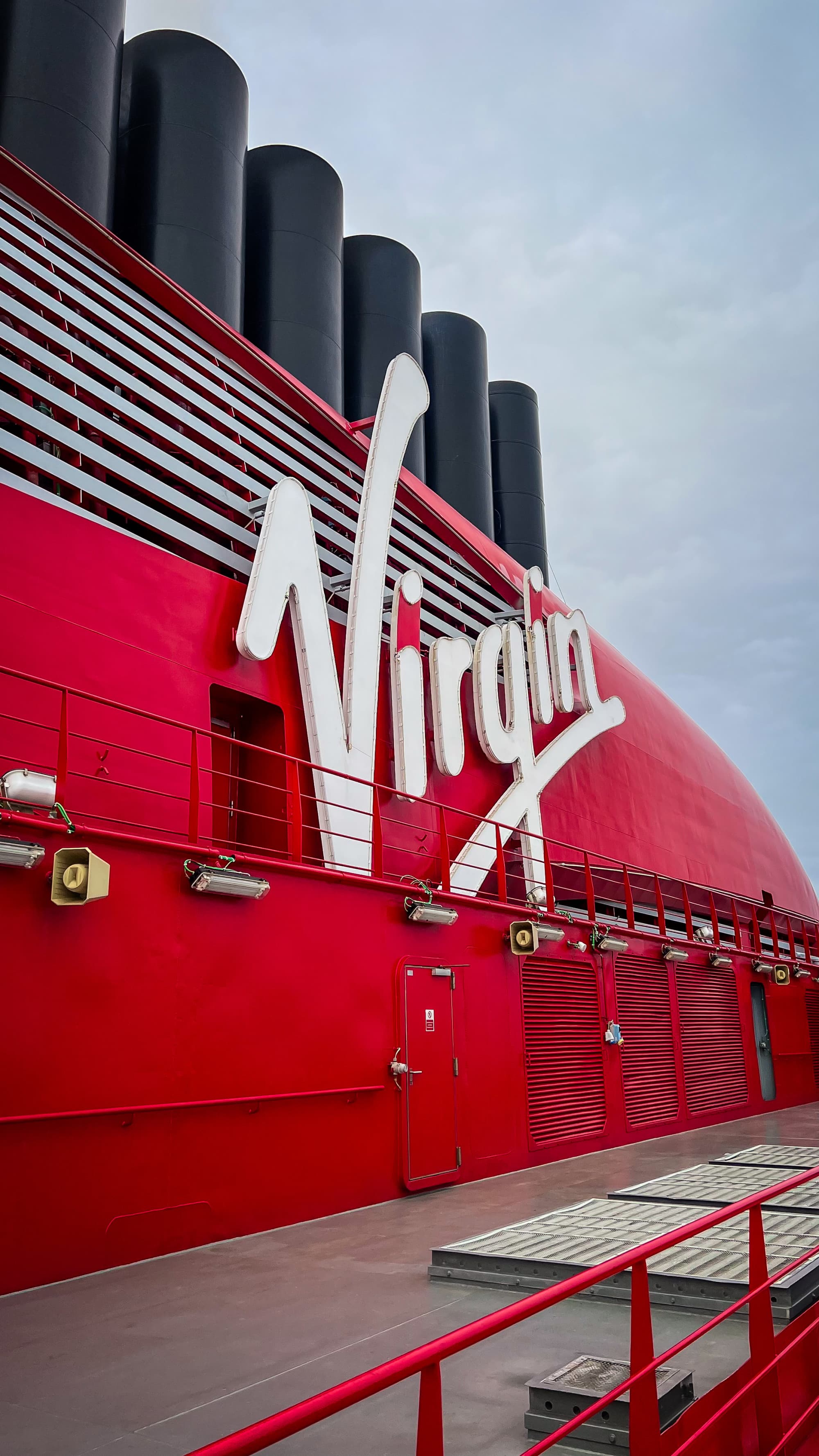 A close-up of the side of the Virgin cruise ship with a large "Virgin" sign