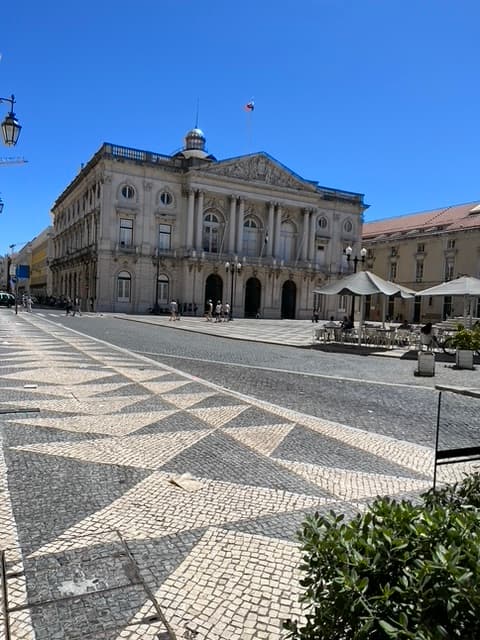stone building with columns amid a courtyard on a sunny day