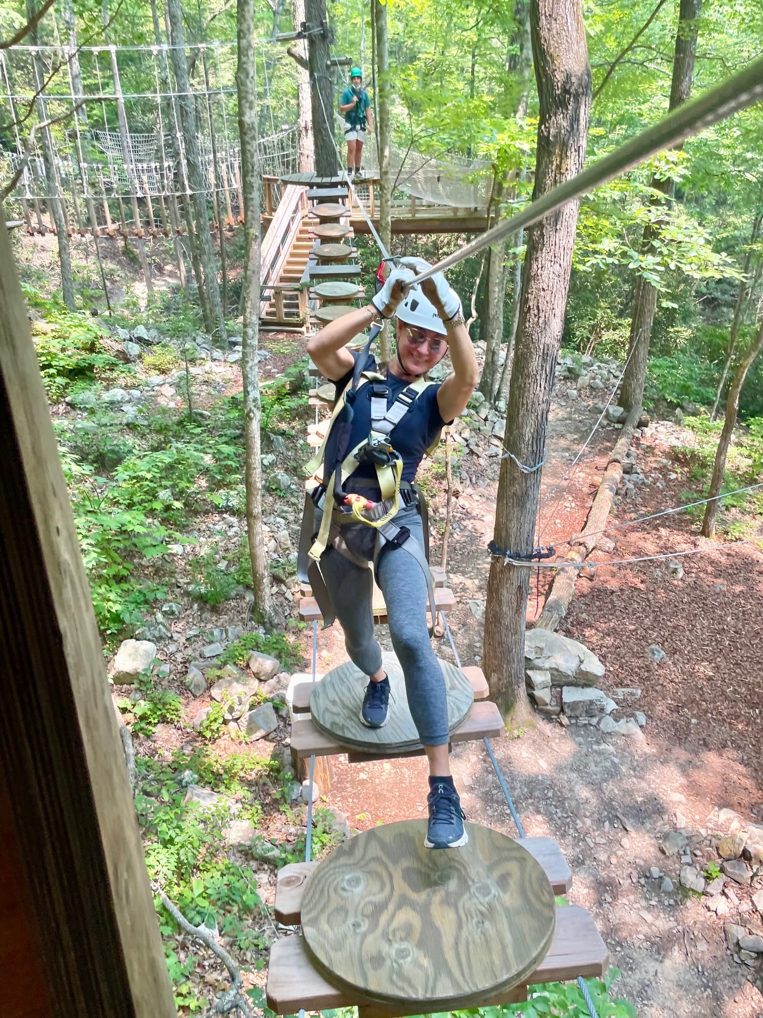 A person zip-lining through the forest with gear and ropes tied to them.