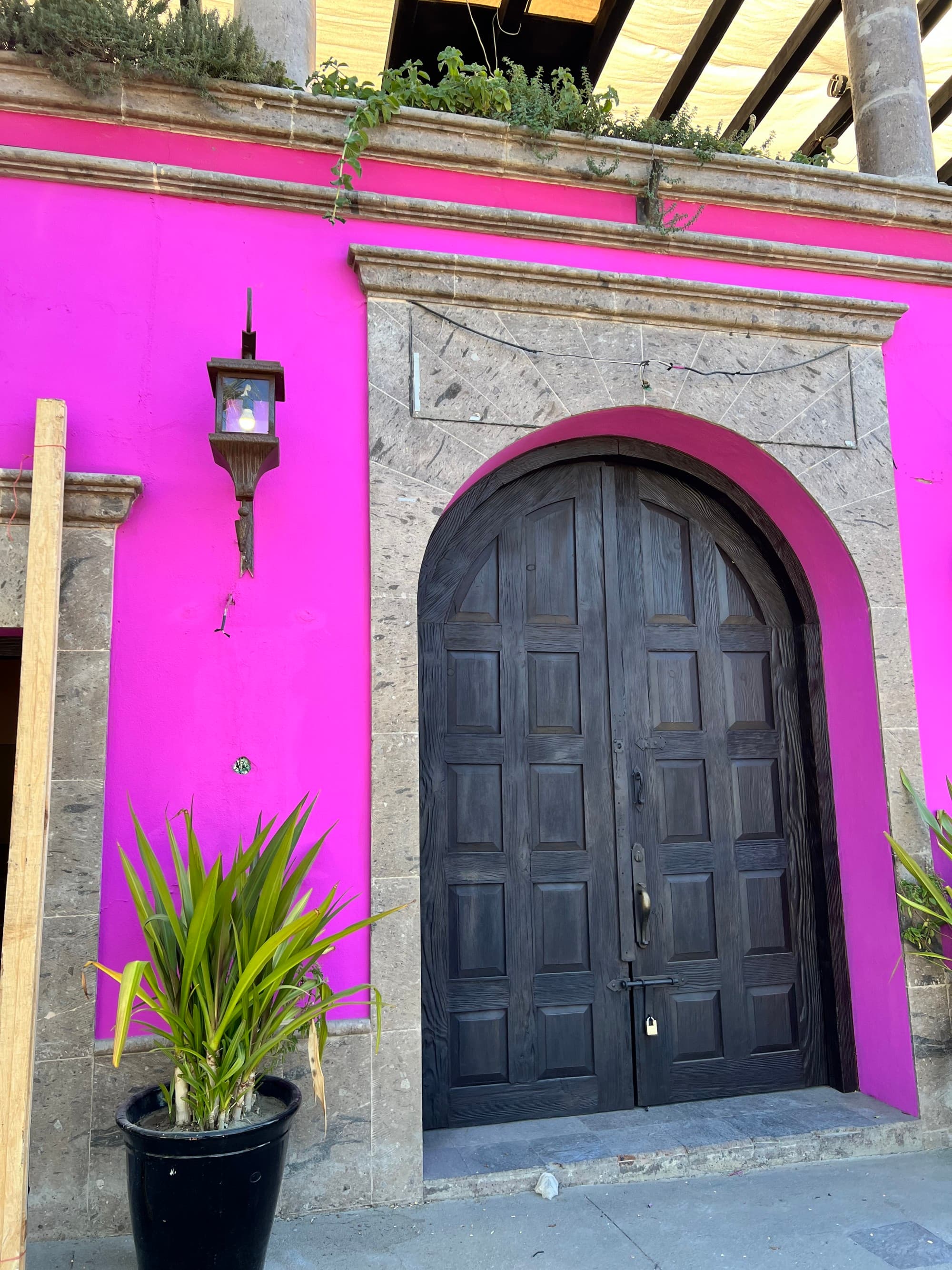 A bright pink building with beautiful old doorway in Todos Santos