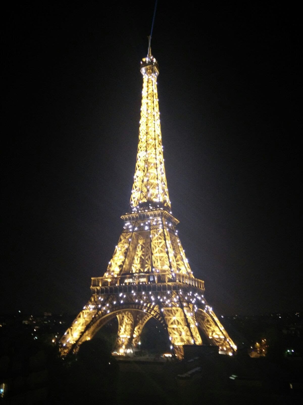 A view of the lit-up Eiffel Tower at night.