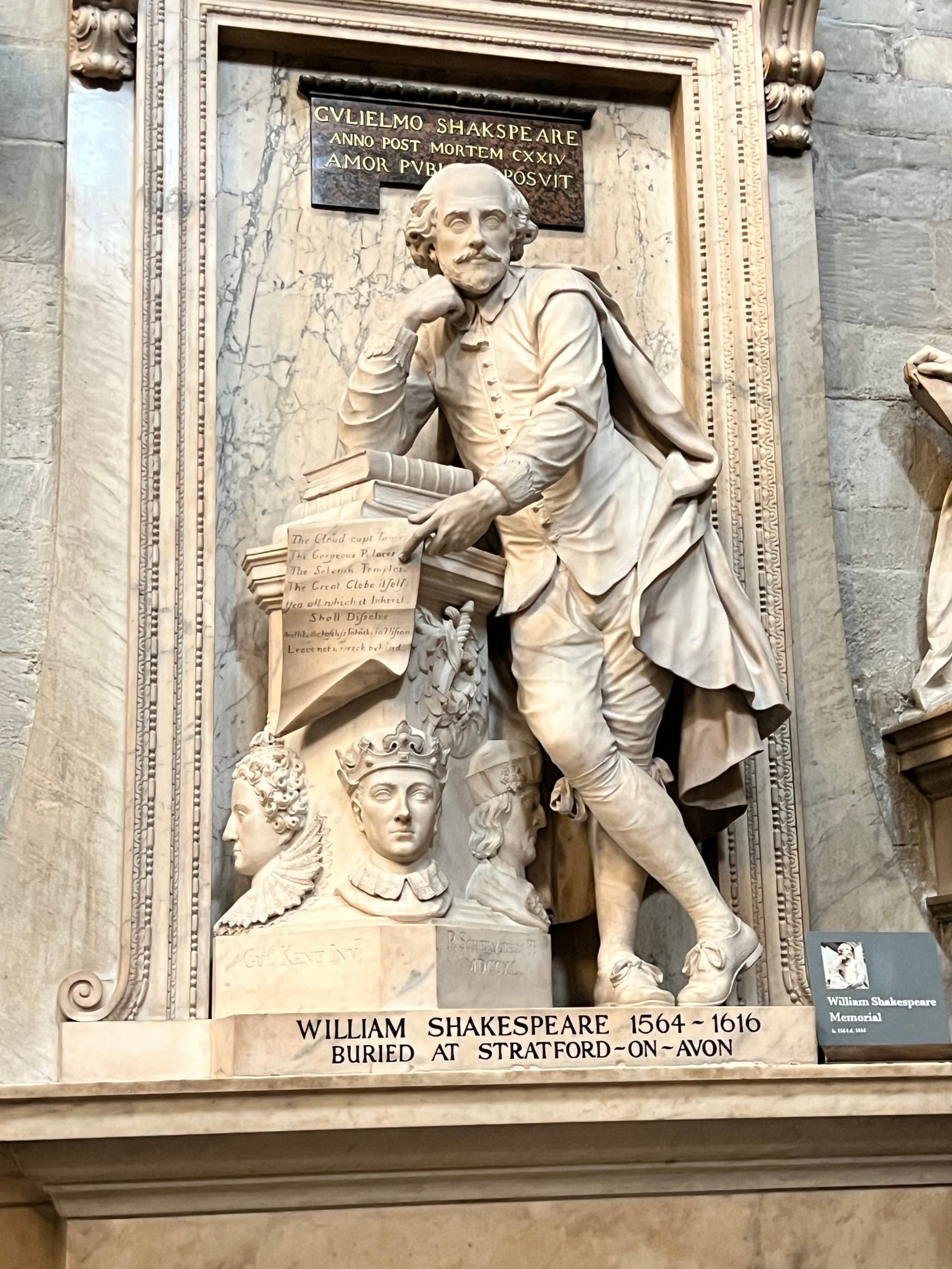 A stone statue memorial to William Shakespeare in Westminster Abbey.