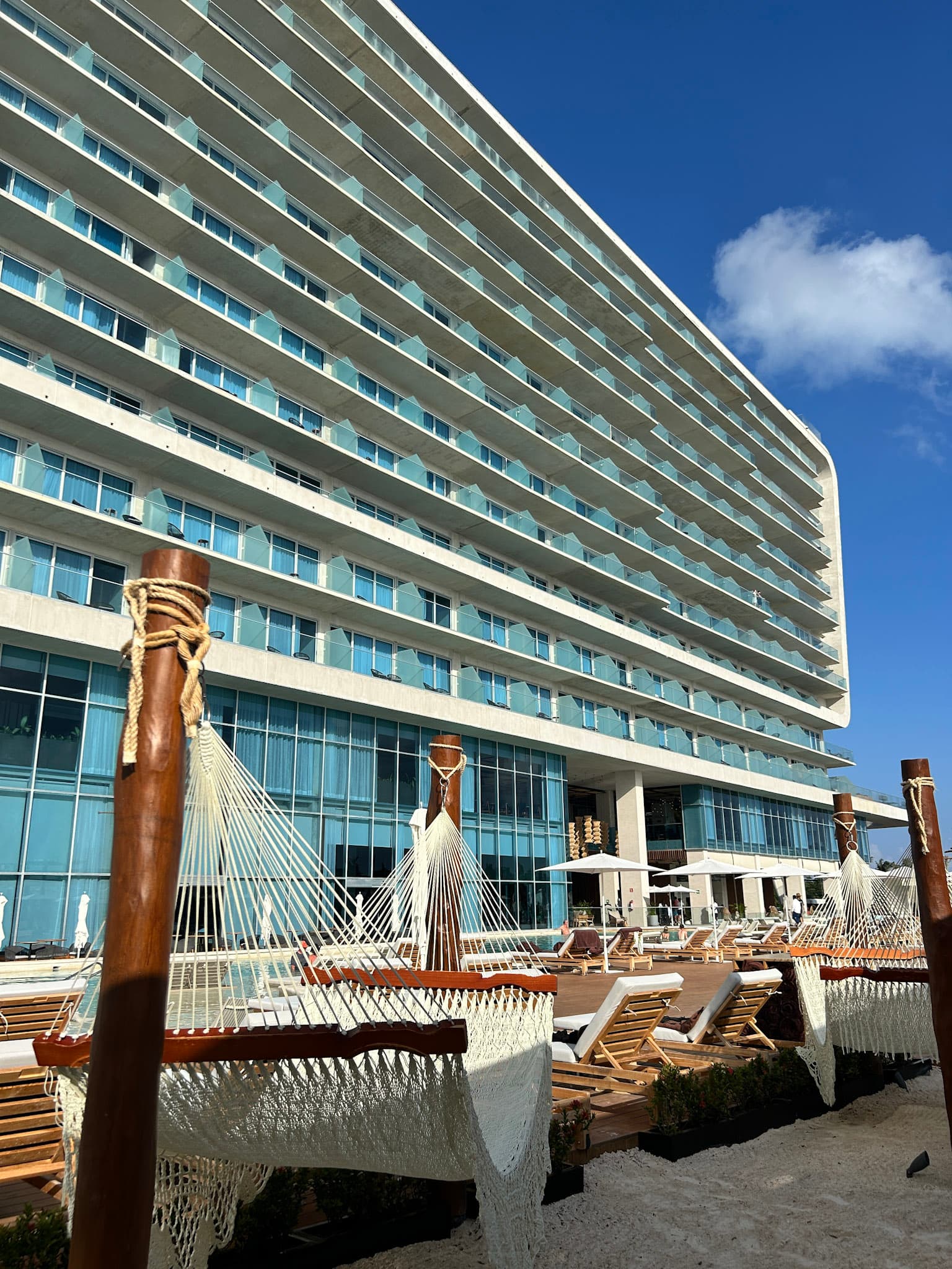 An outdoor and sunny lounge area of the hotel with sun beds and hammocks.