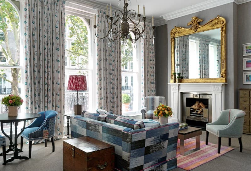 a luxe living room with an ornate chandelier and floor-to-ceiling windows