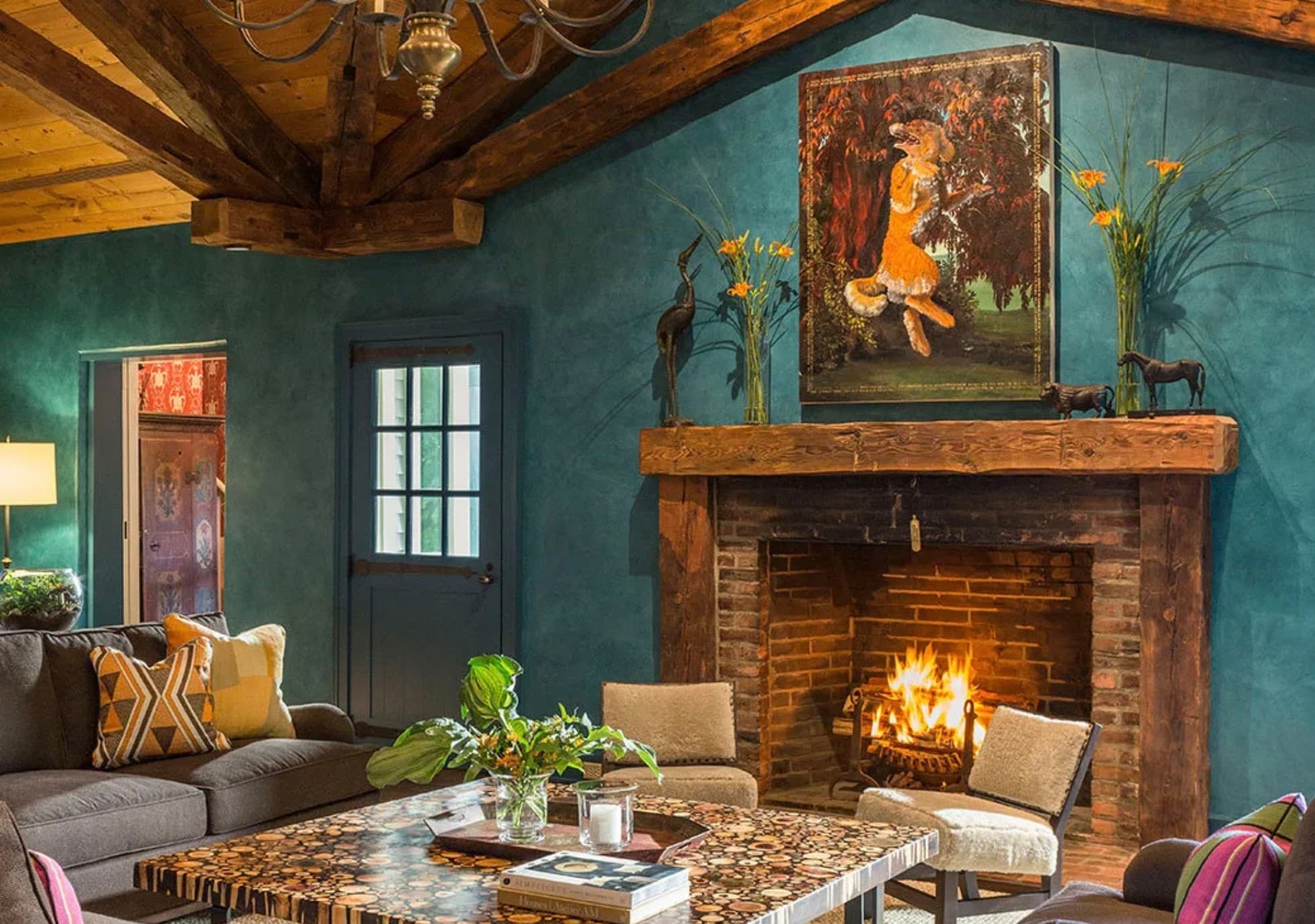 green sitting room with fireplace and art